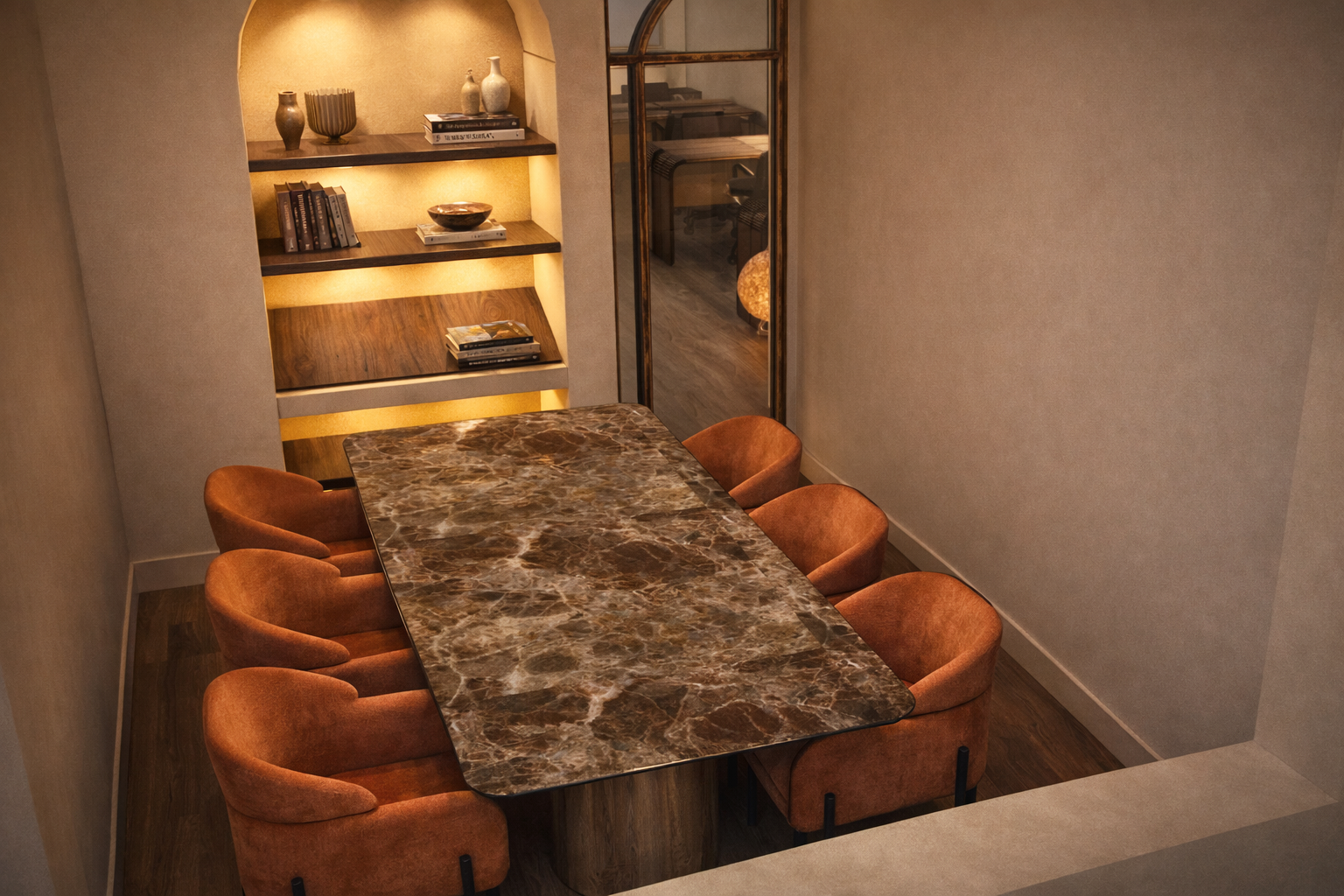 A dining room with a large marble top table and eight orange velvet chairs, beige walls, and a built-in wooden bookshelf with decorative vases and books, lit with warm lighting.