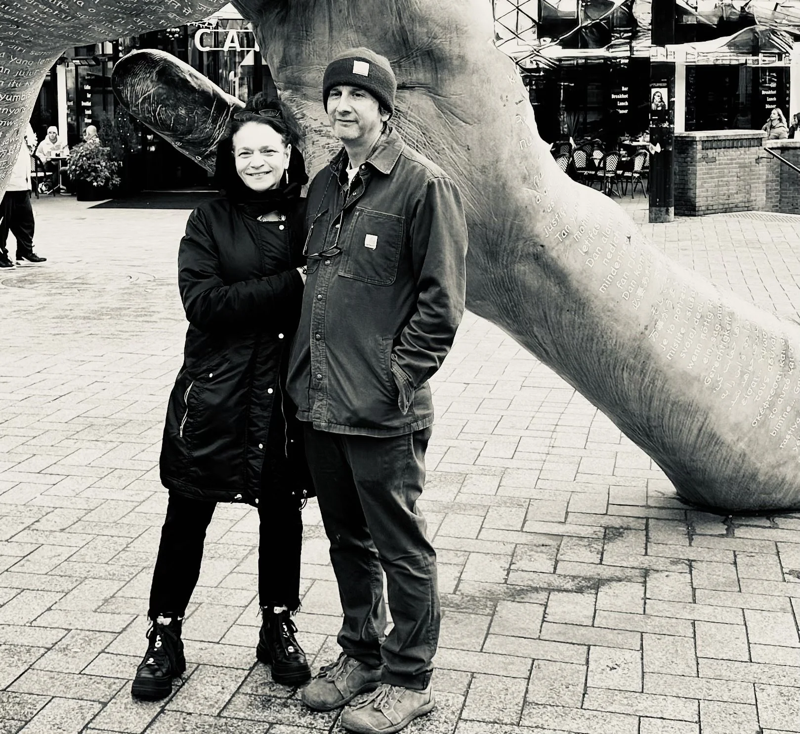 A black-and-white photo of Monique King and Paul Rosenbluh standing outside in cold-weather attire.
