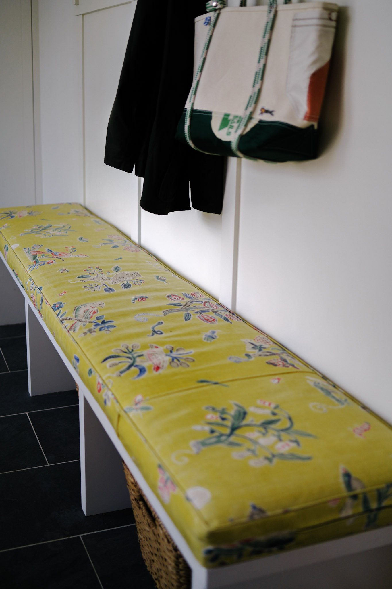 Custom upholstered bench with floral fabric and wicker basket accents, styled by Brookfield Hunt Studio in Portland, Maine.