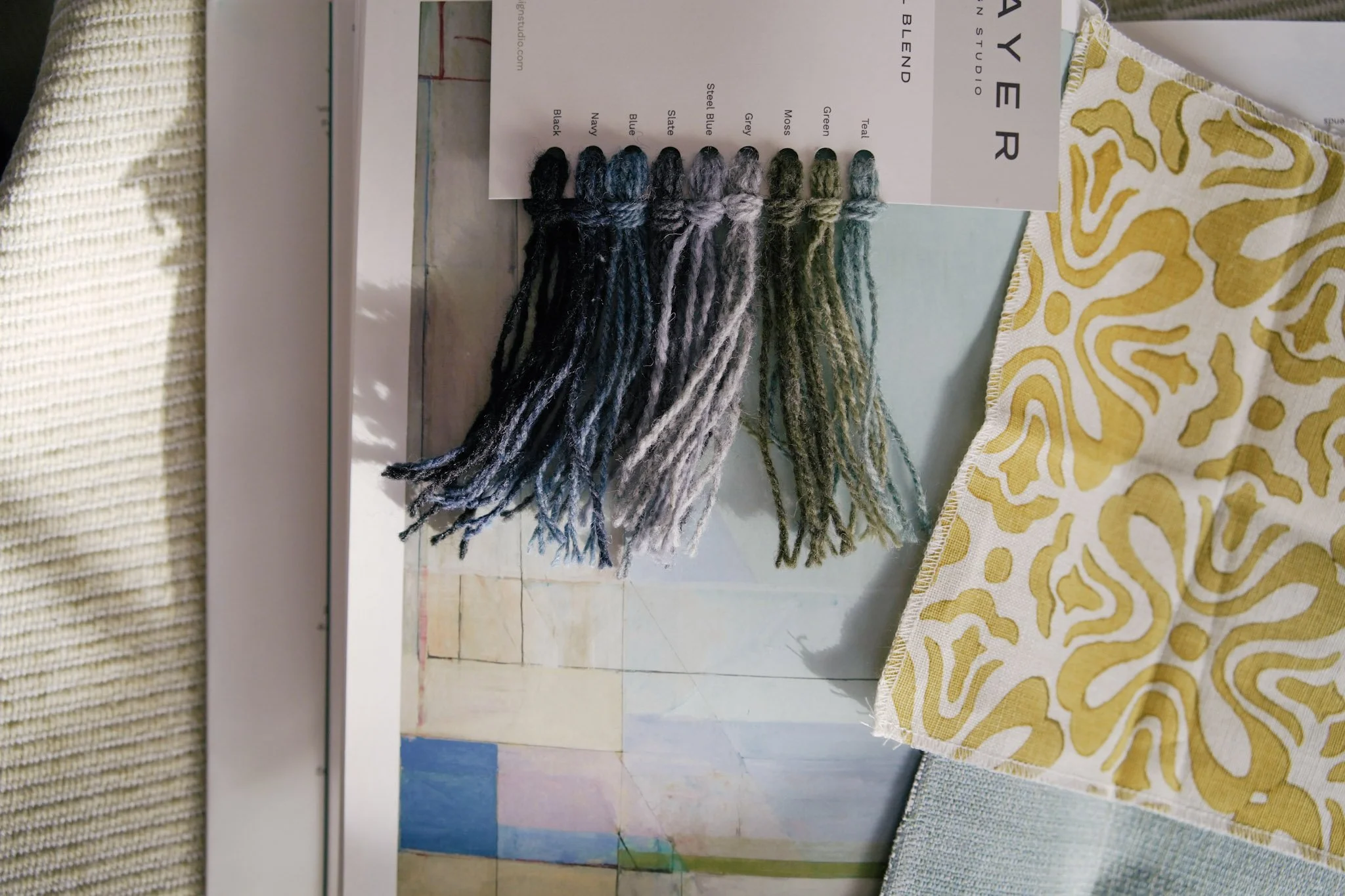 Color and pattern swatches laid out alongside a yellow and white abstract fabric sample