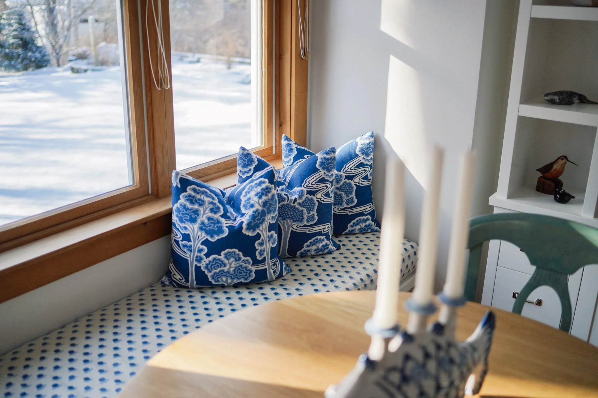 Custom window seat with blue and white patterned cushions designed by a Portland, Maine interior designer.