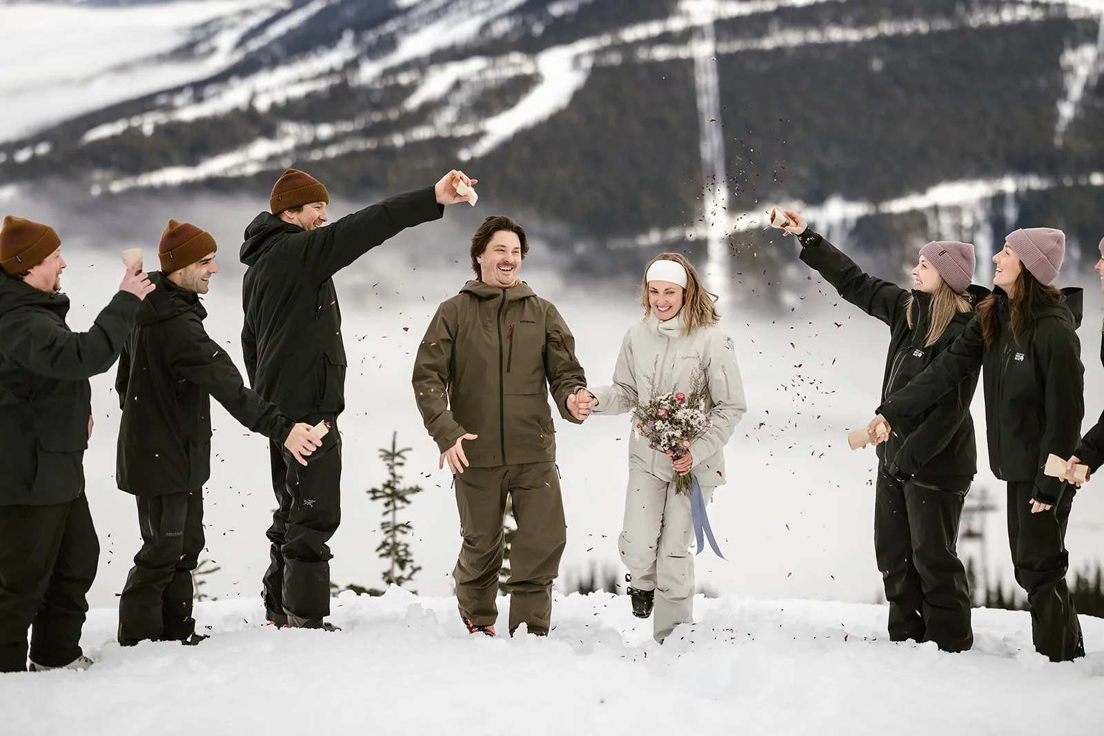 A wedding celebration in a snowy mountain landscape, with a bride and groom holding hands and people around them celebrating with tossing confetti and cheering.