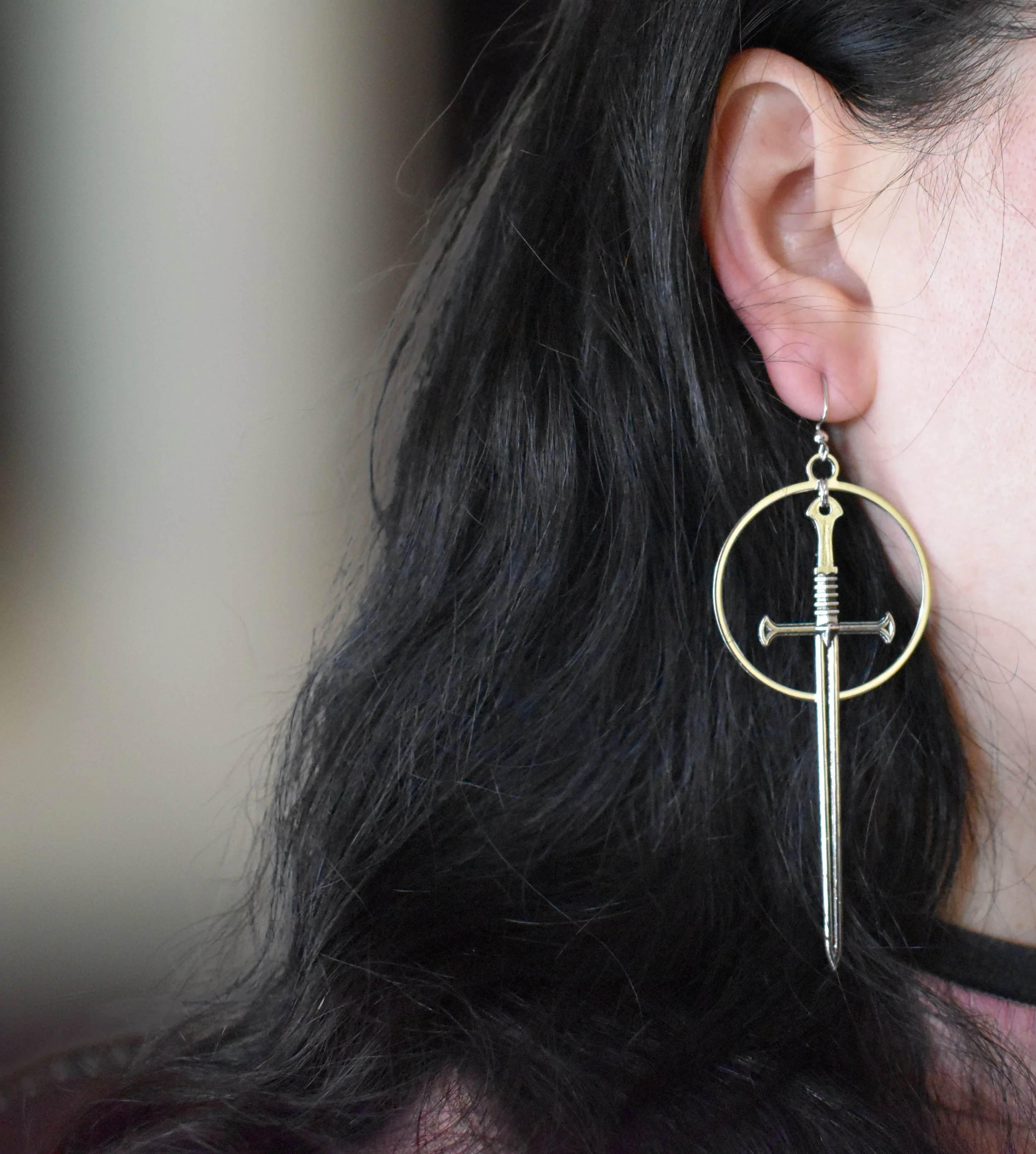 Silver-coated brass earrings featuring a 3-inch sword charm on a 1.5-inch hoop, nickel-free