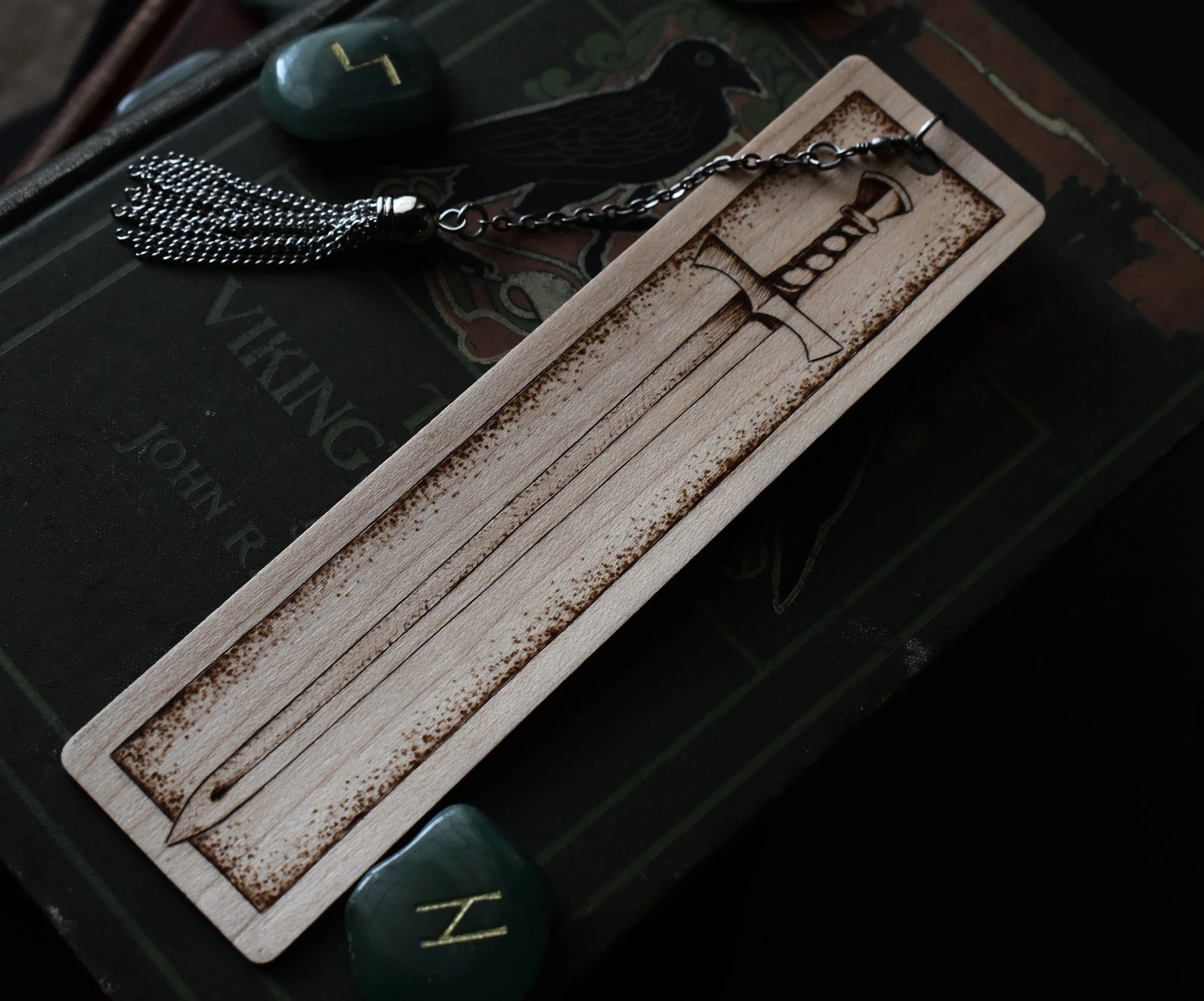 Wood-burned medieval sword bookmark with intricate vine patterns, crafted from maple and brass