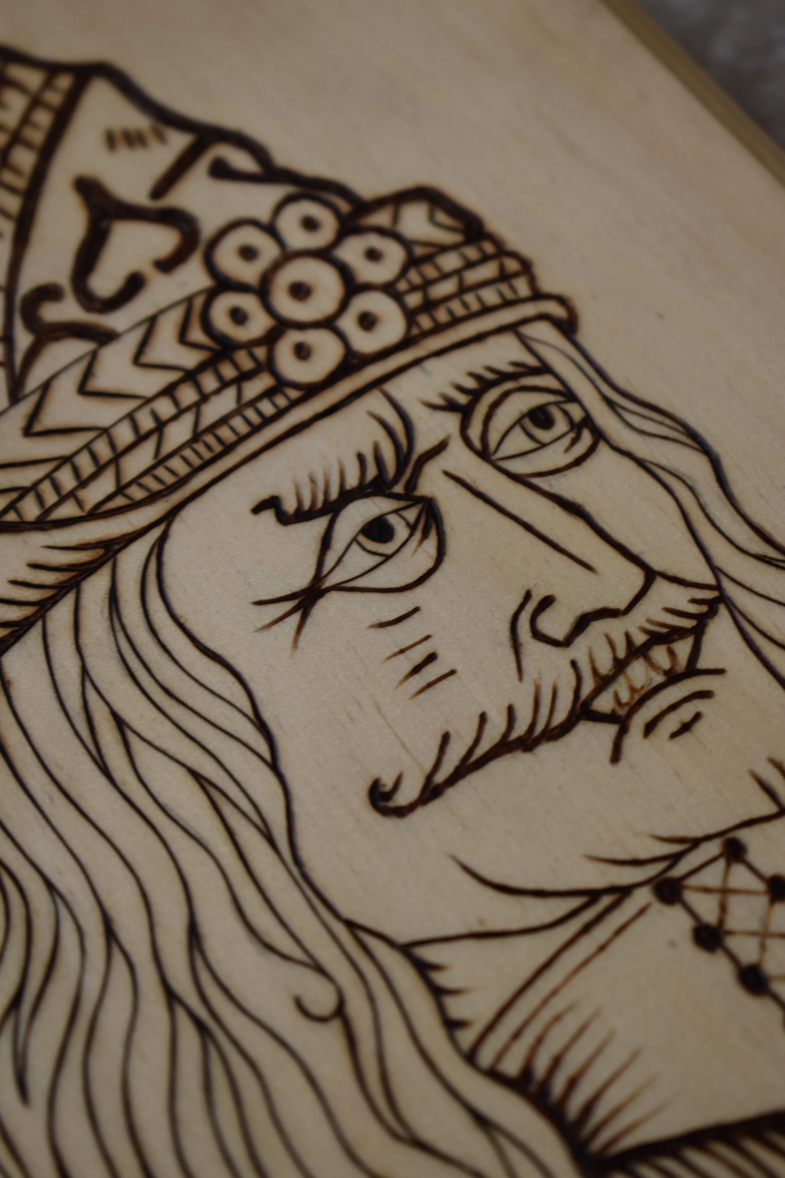 Handcrafted wood-burned portrait of Vlad the Impaler, inspired by a 15th-century engraving, on basswood.