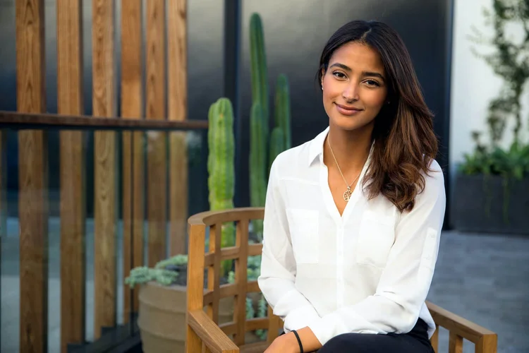 Marisa, therapist, standing in front of a wooden trellis with cacti