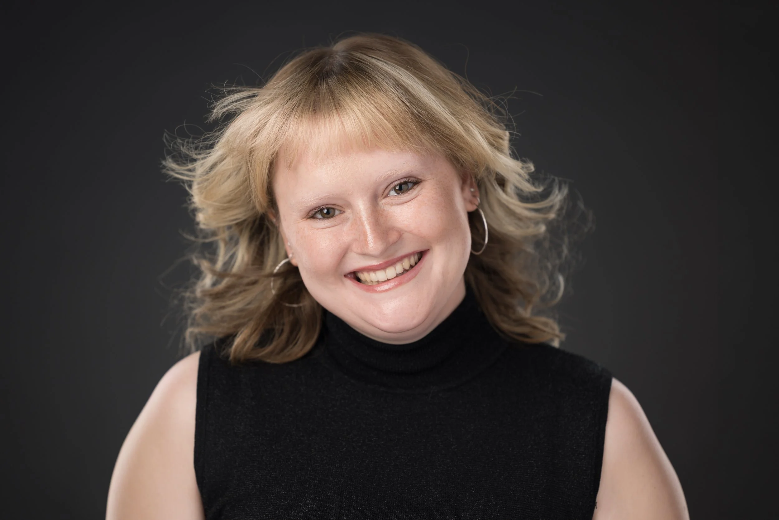 A woman with bangs laughing