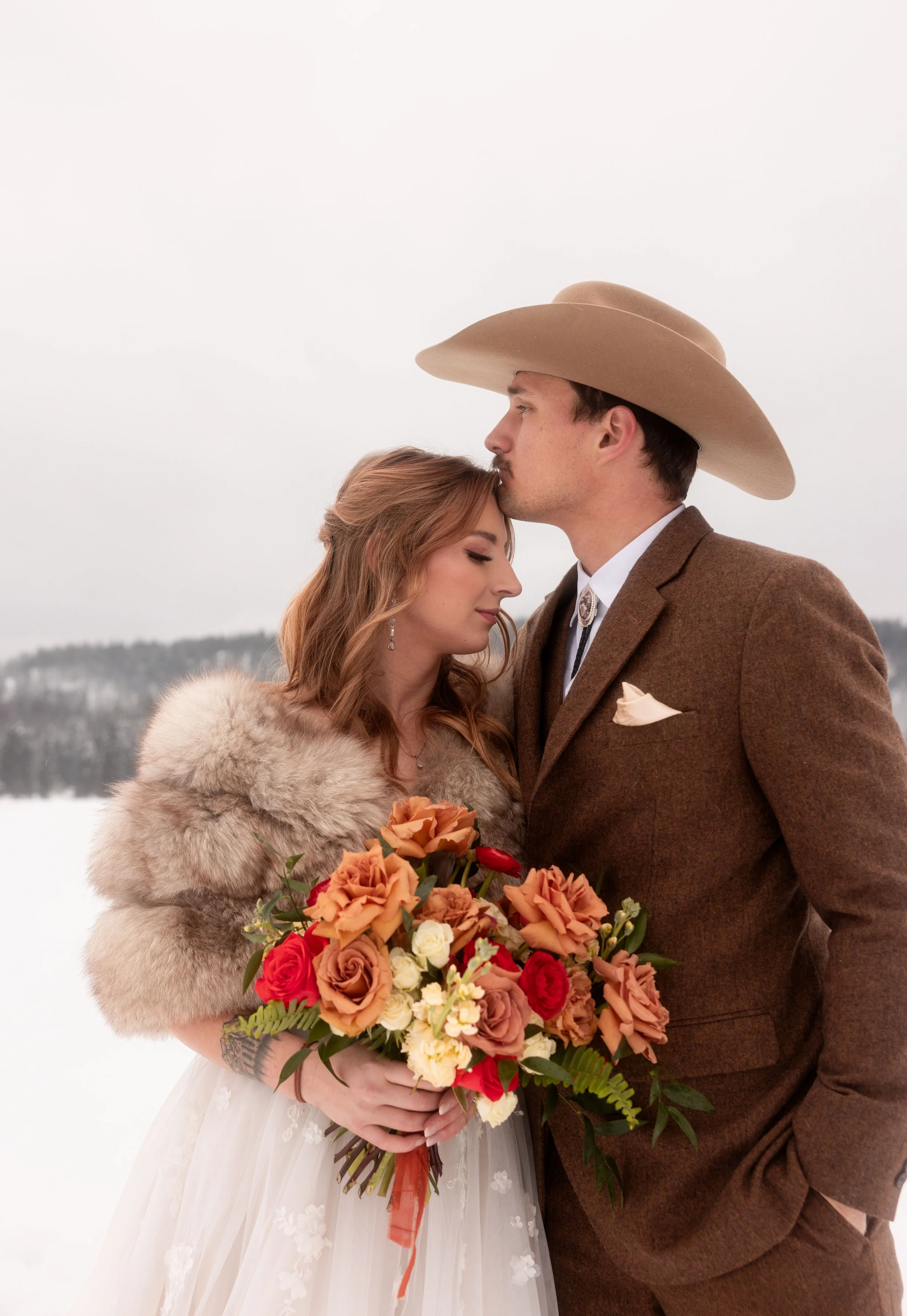 A newly married couple posing for a photo in western attire.