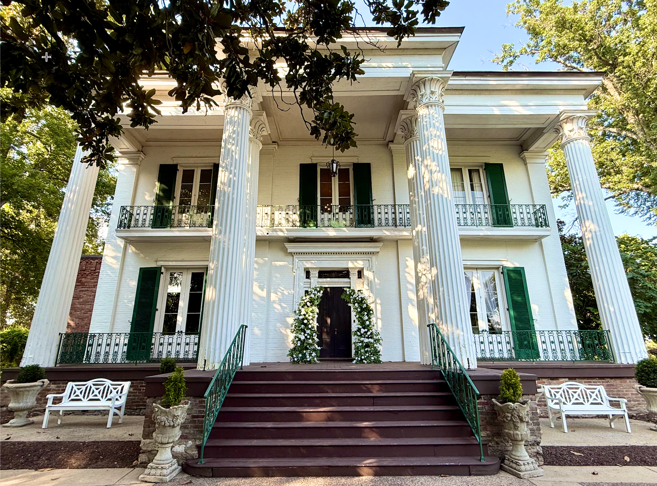 A beautiful white rose and greenery broken floral arch installed at the main entrance stairs of the historic Riverwood Mansion in Nashville.