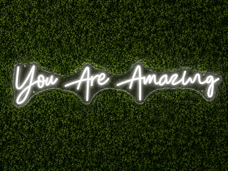 You Are Amazing white LED neon sign rental on clear acrylic displayed on a boxwood wall in Nashville