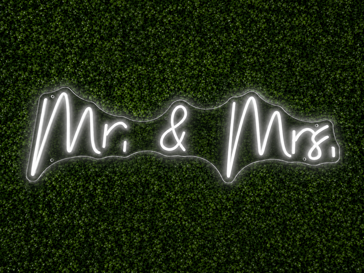 Mr. and Mrs. white LED neon sign rental on clear acrylic displayed on a boxwood wall for a Nashville wedding