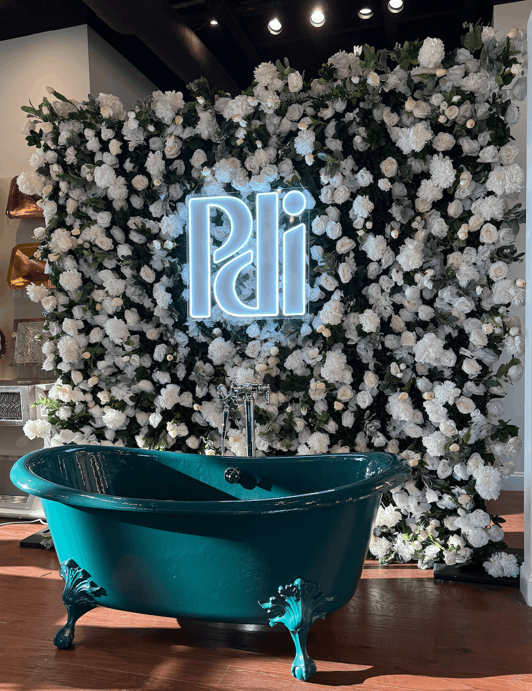 Custom LED neon logo sign displayed on a flower wall for a corporate brand activation