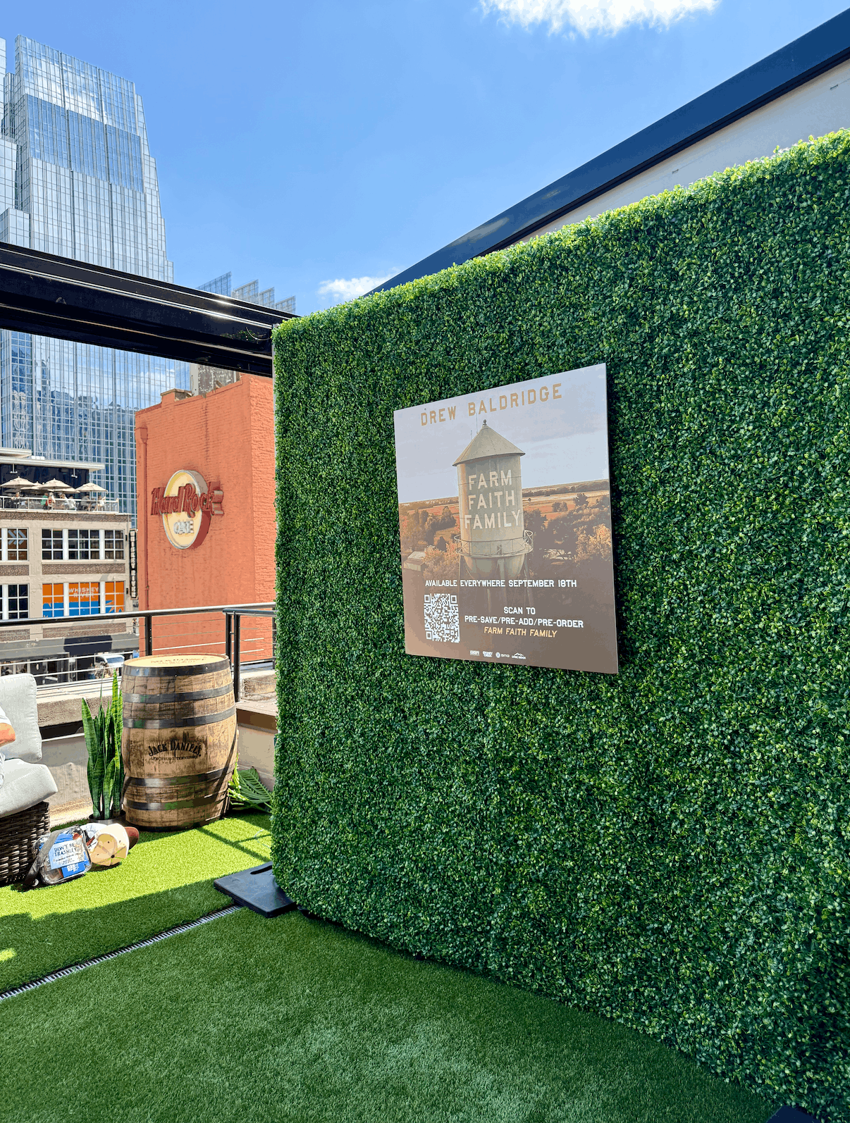 A boxwood greenery wall backdrop installed for a corporate music artist event on a downtown Nashville rooftop patio at Hard Rock Cafe Nashville.