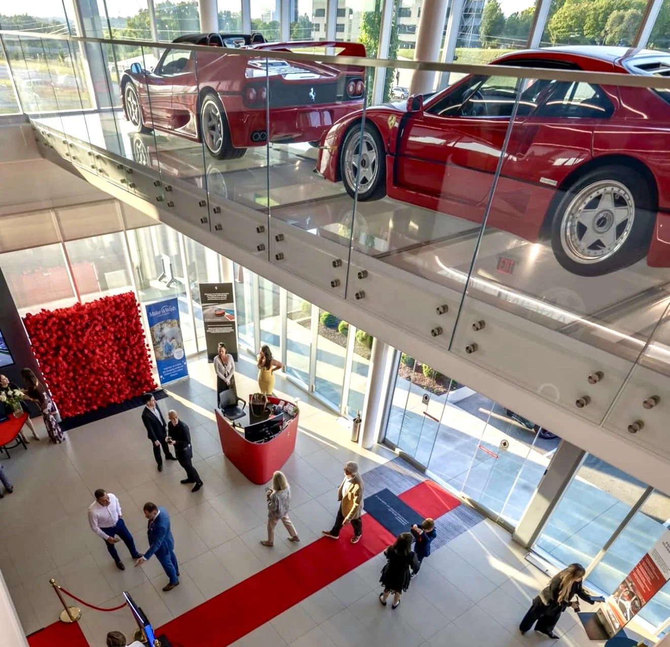 Premium corporate event backdrops and luxury brand activation ideas featuring a massive red rose flower wall at a Ferrari showroom