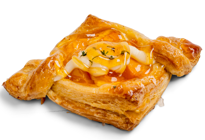 A savory pastry square topped with a dollop of butter and honey, garnished with a sprig of herbs.