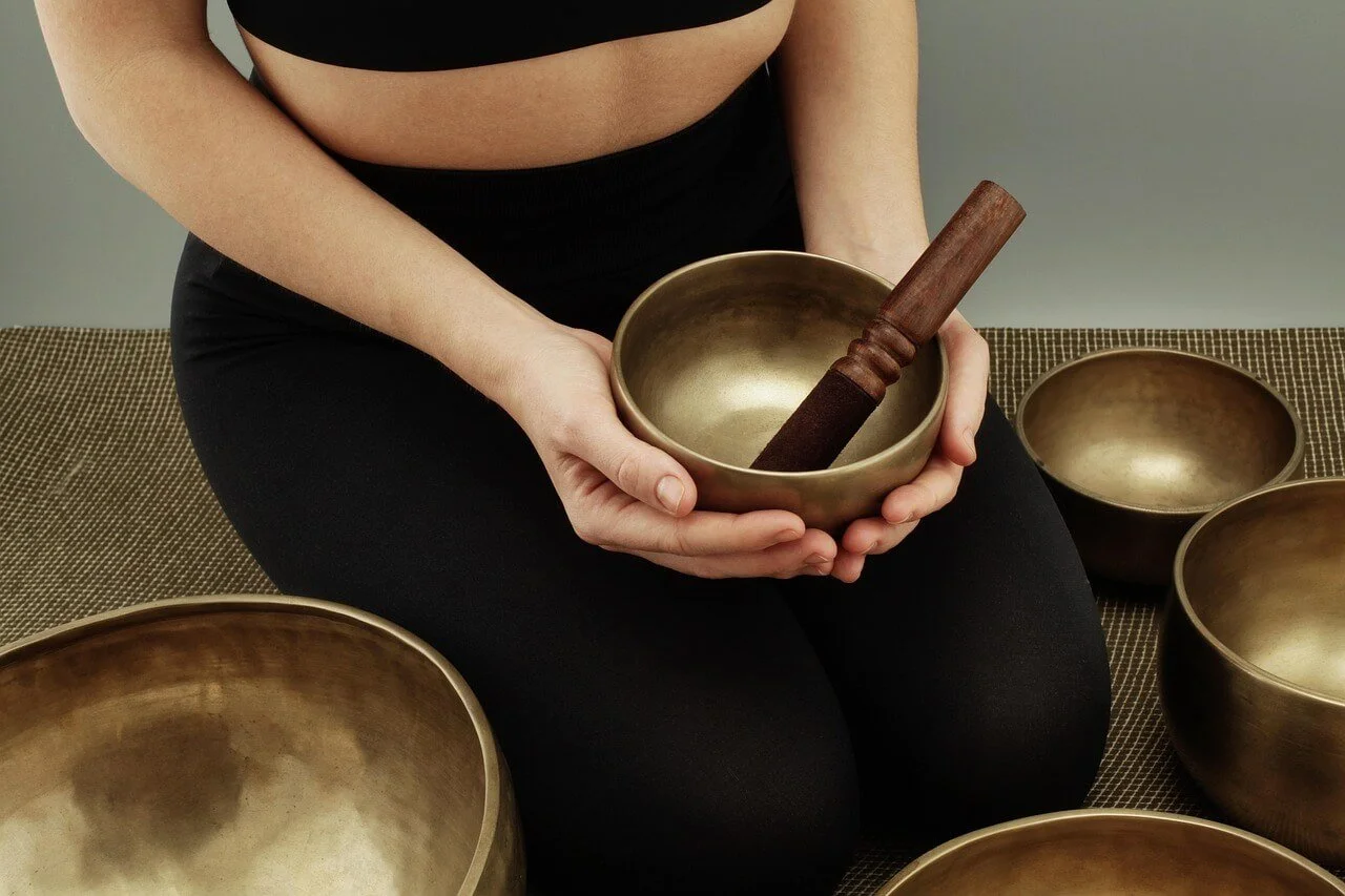 Woman sitting with a set of Tibetan singing bowls