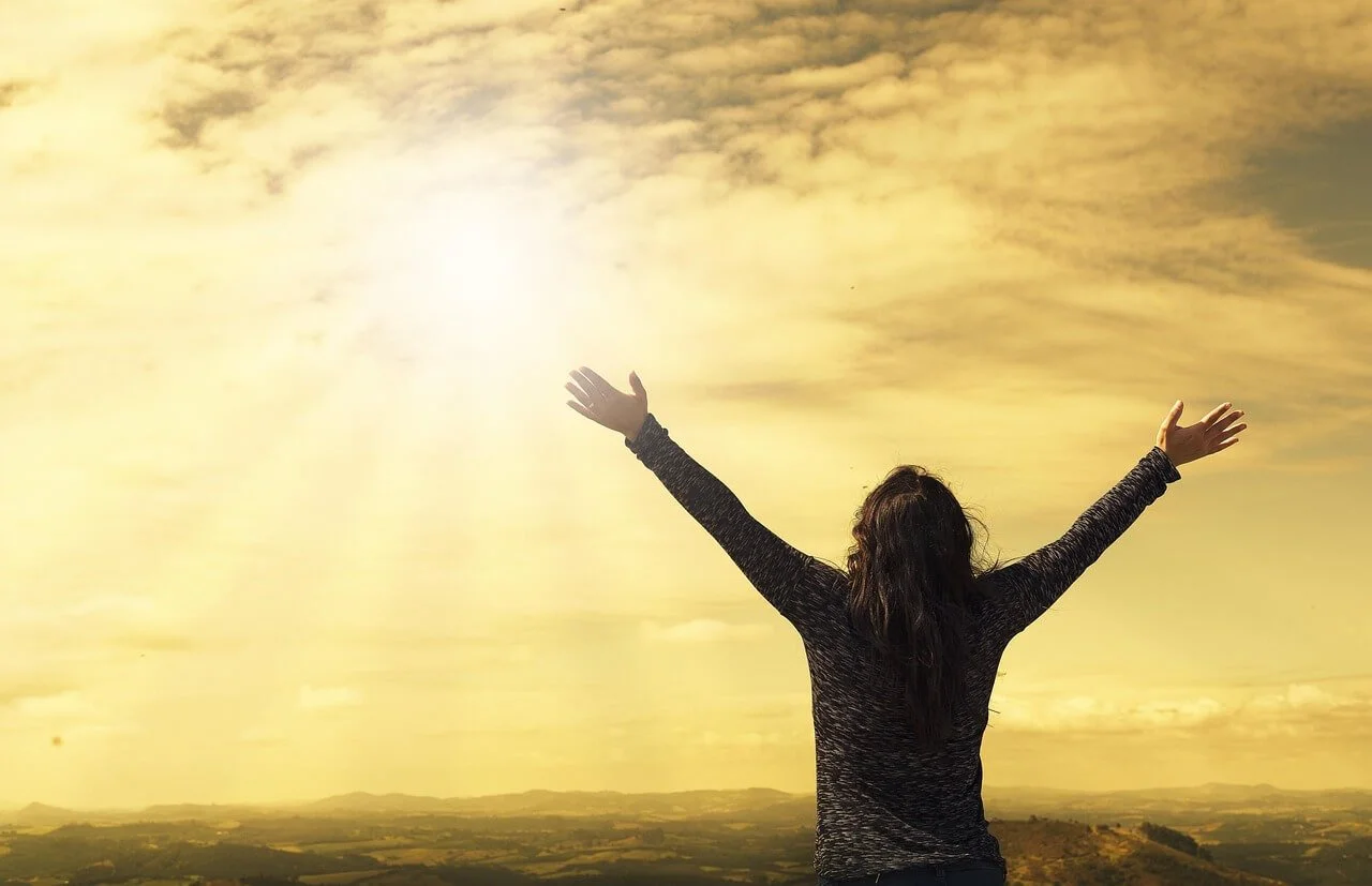 Woman raising arms to the sun