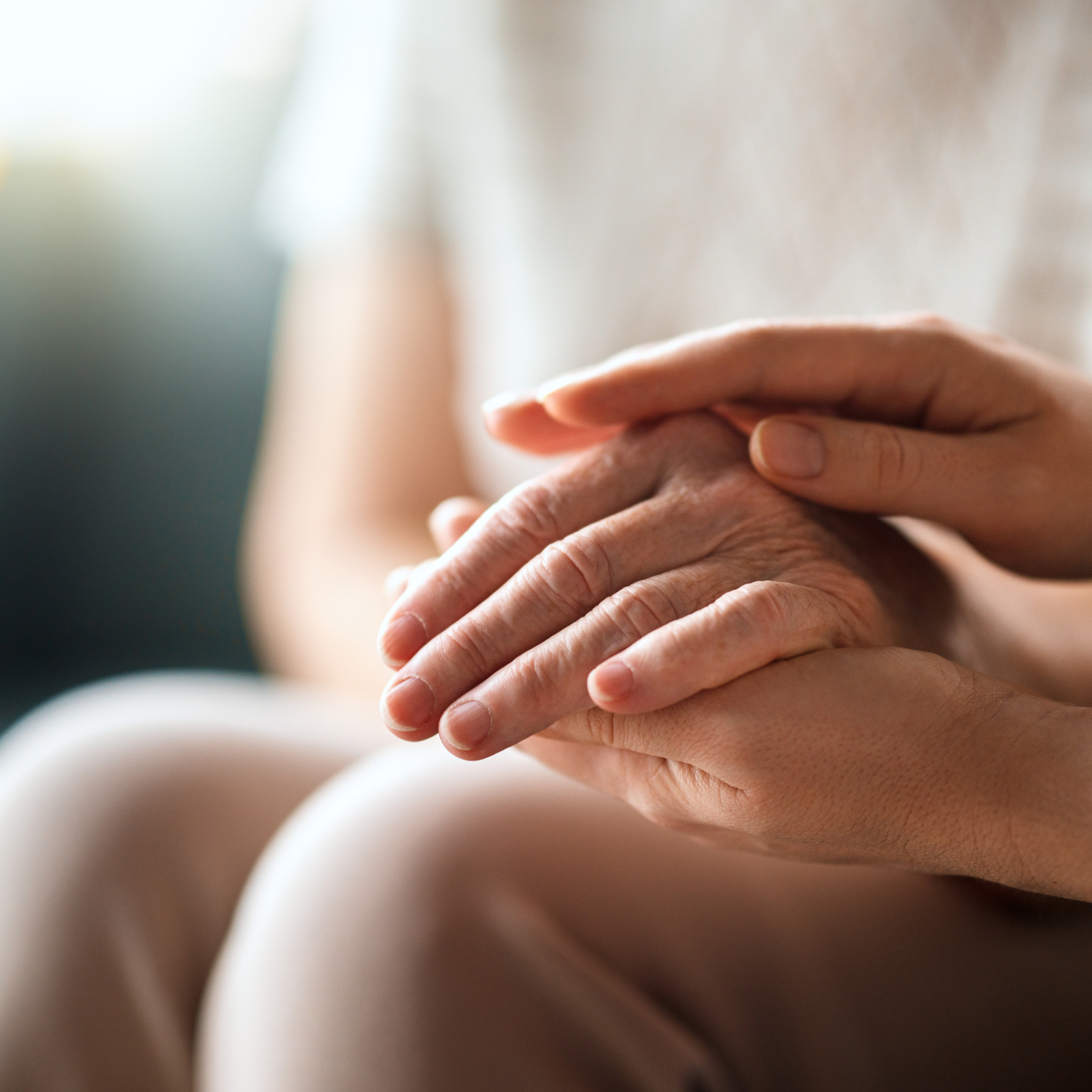 Hands offering gentle support and reassurance, representing compassionate occupational therapy care for people living with Functional Neurological Disorder (FND)