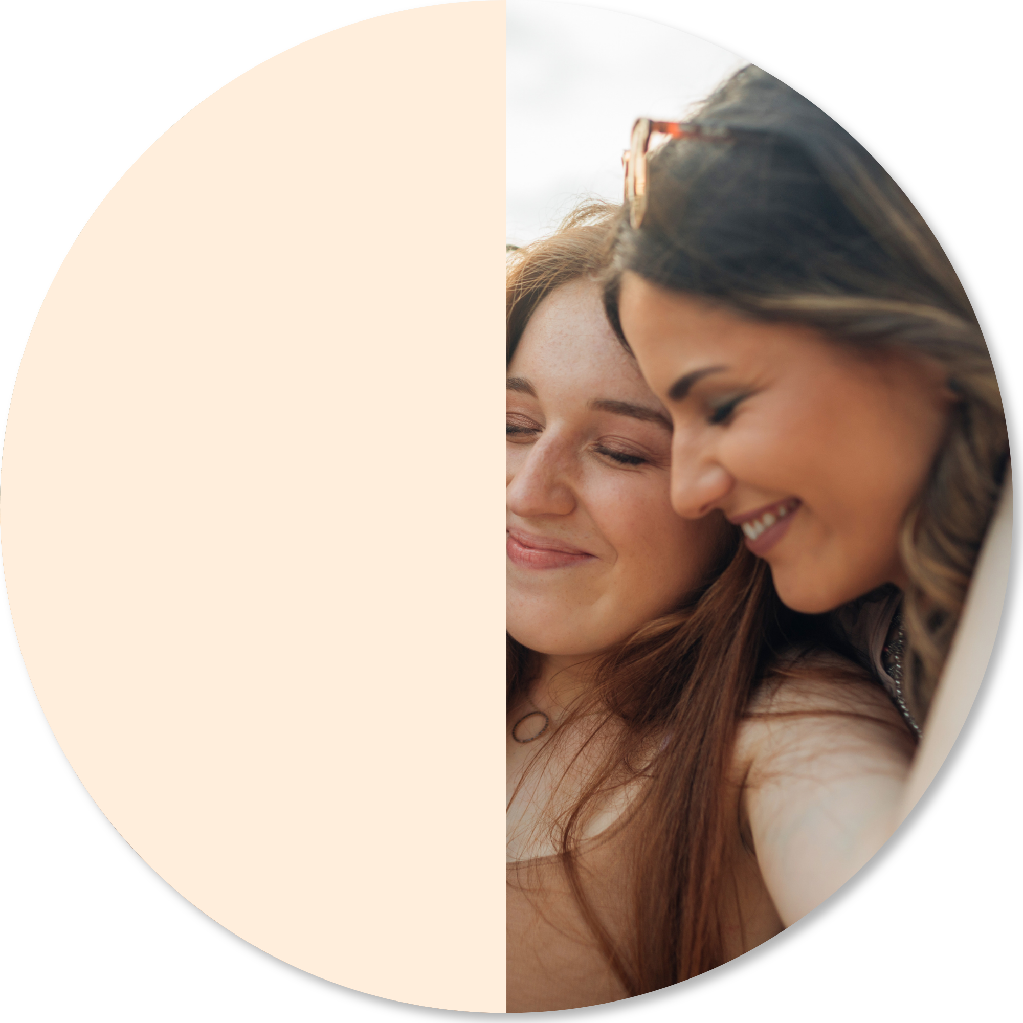 Close-up of smiling women with closed eyes, sharing a moment of joy, outdoors during daytime.