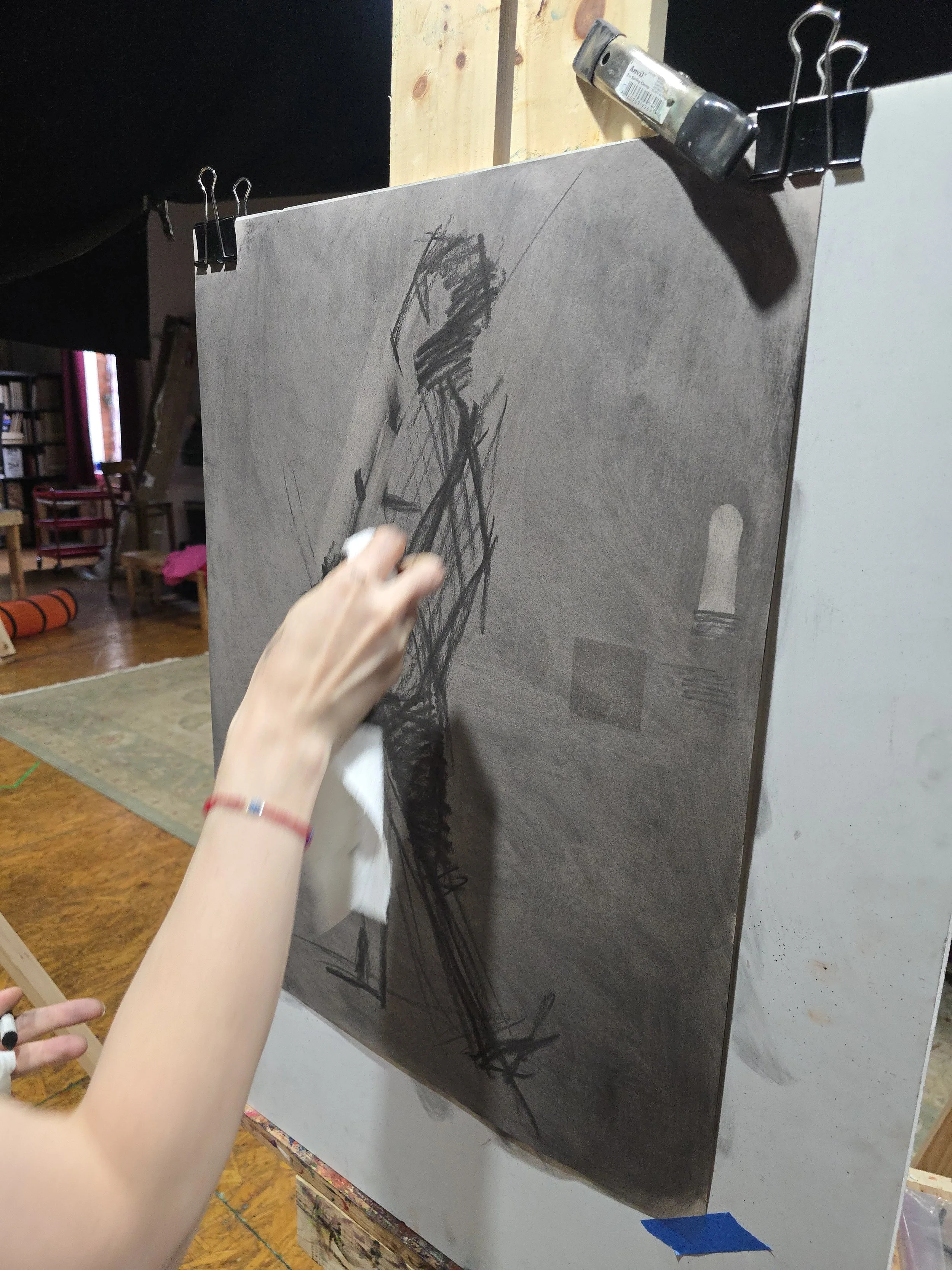 Close-up of an artist sketching gesture drawing with charcoal .