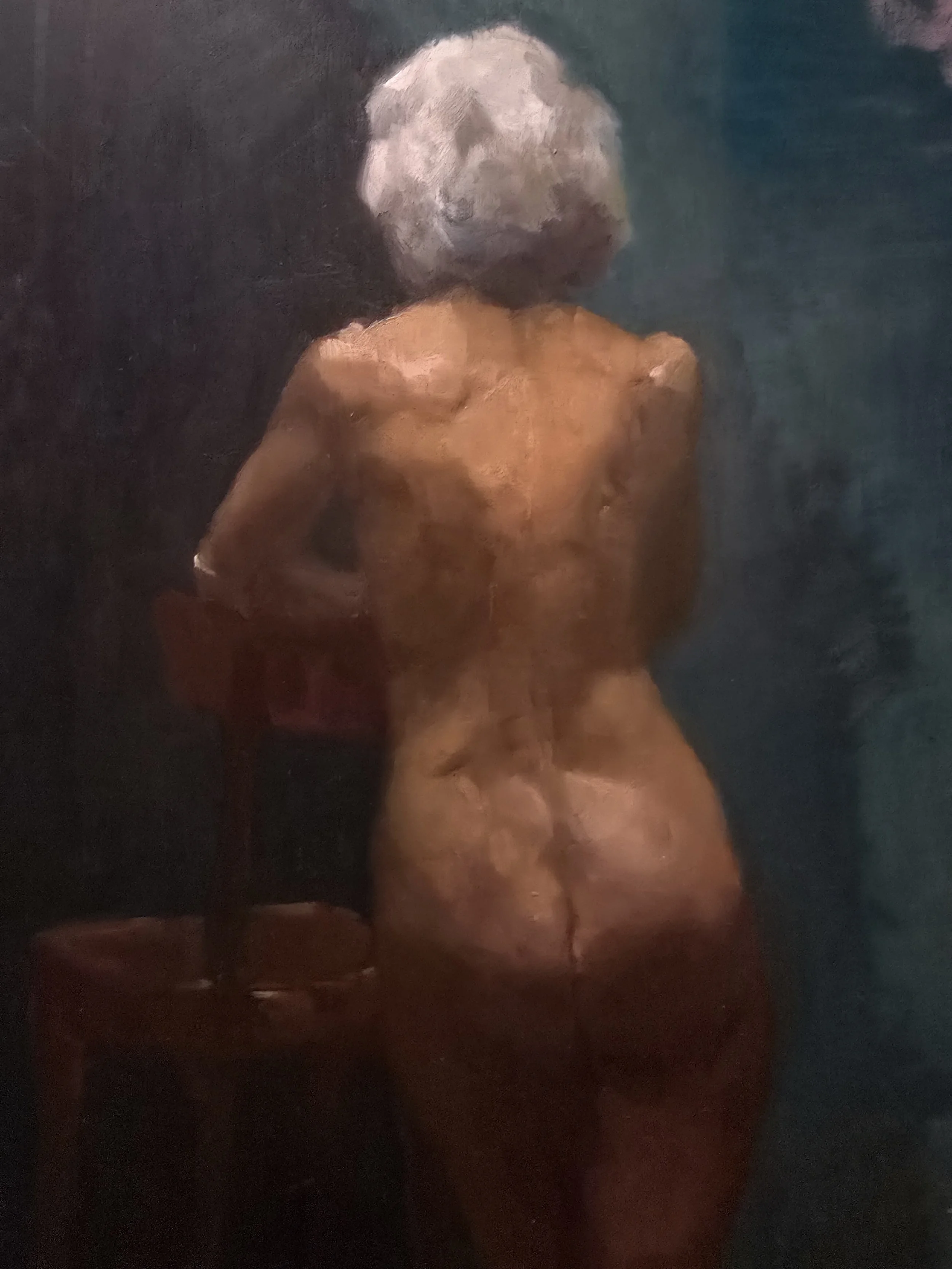 Student Work from Art Class. Painting of a nude woman with curly gray hair standing with her back to the viewer, in a dark setting.