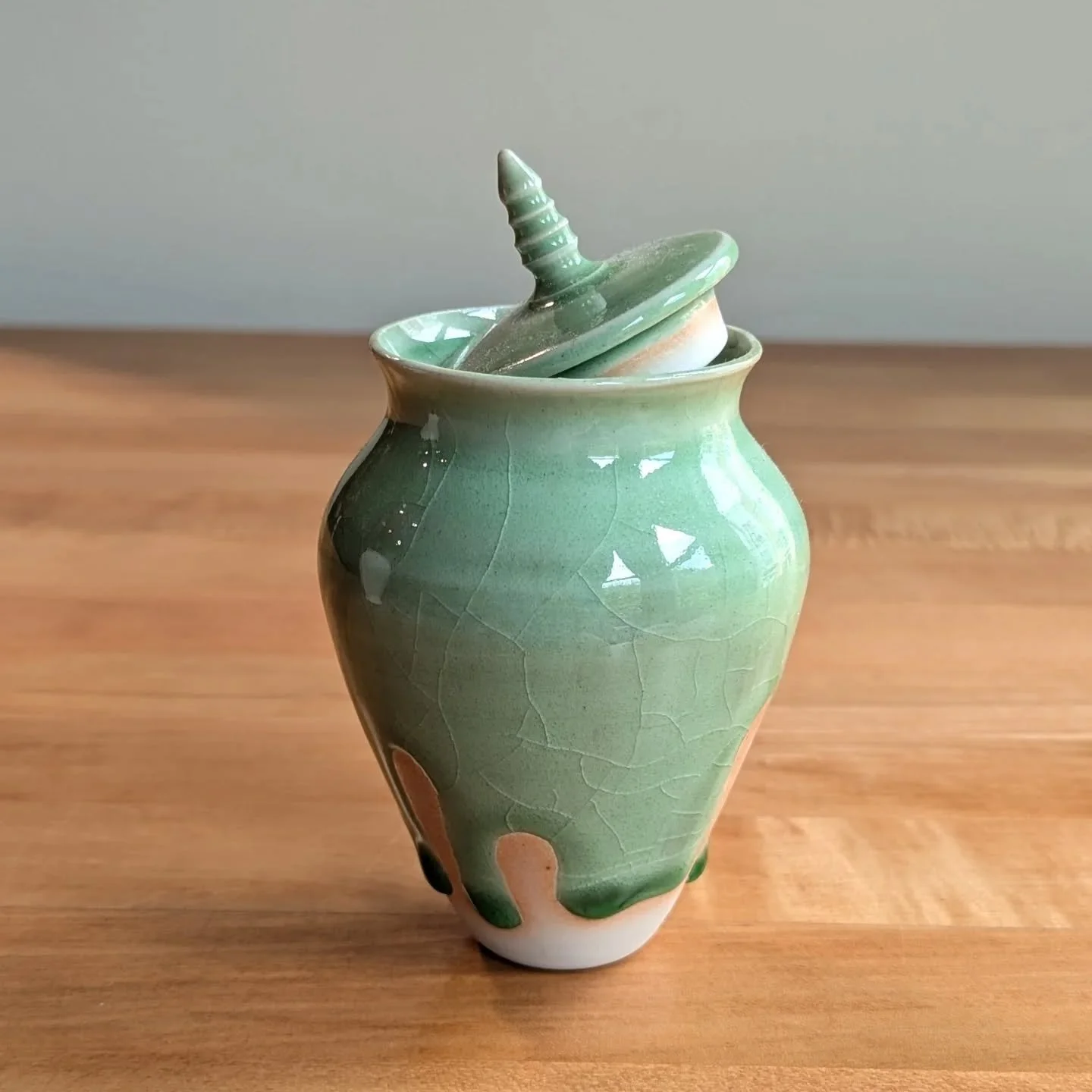 Small drippy jar

BMix clay body with Kittens green glaze in gas. 

I used wax resist to accentuate the drips and the glaze pooled in the low spots in the kiln! The cracks on the side are called &quot;crazing&quot;. The glaze has shrunk more than the