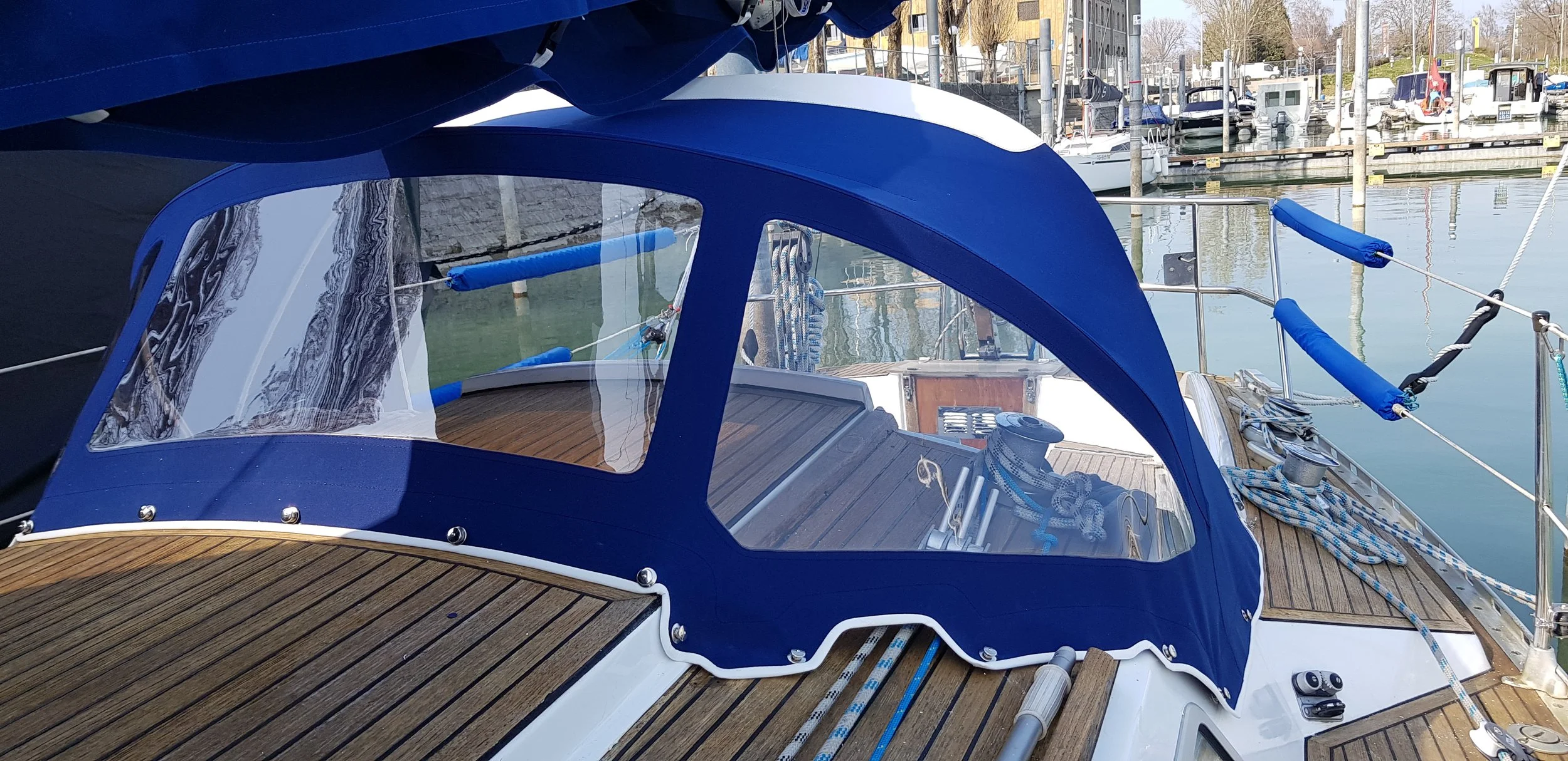 Blick auf das Cockpit einer Segelyacht mit blauem Verdeck im Hafen.