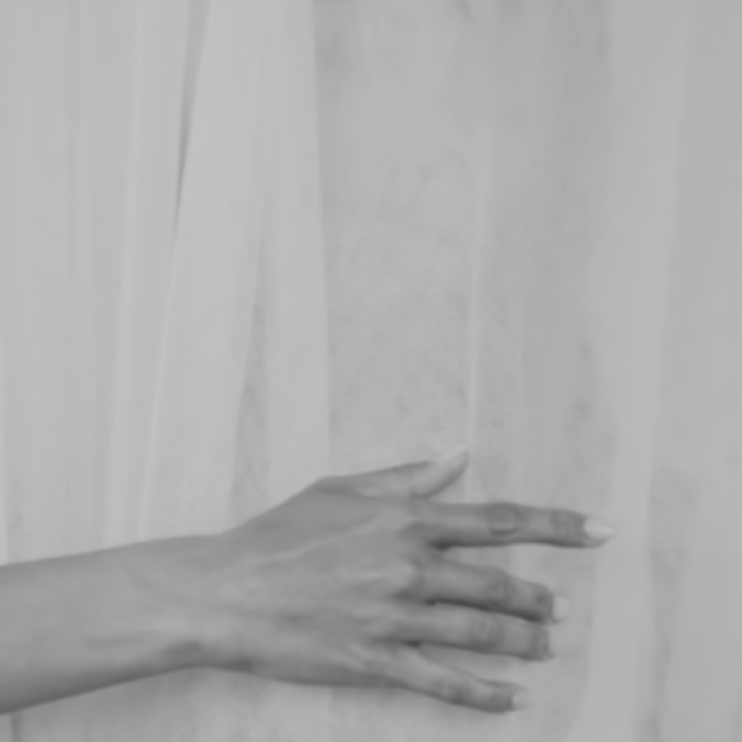 Un fianco femminile parzialmente coperto da una mano con le dita distese.