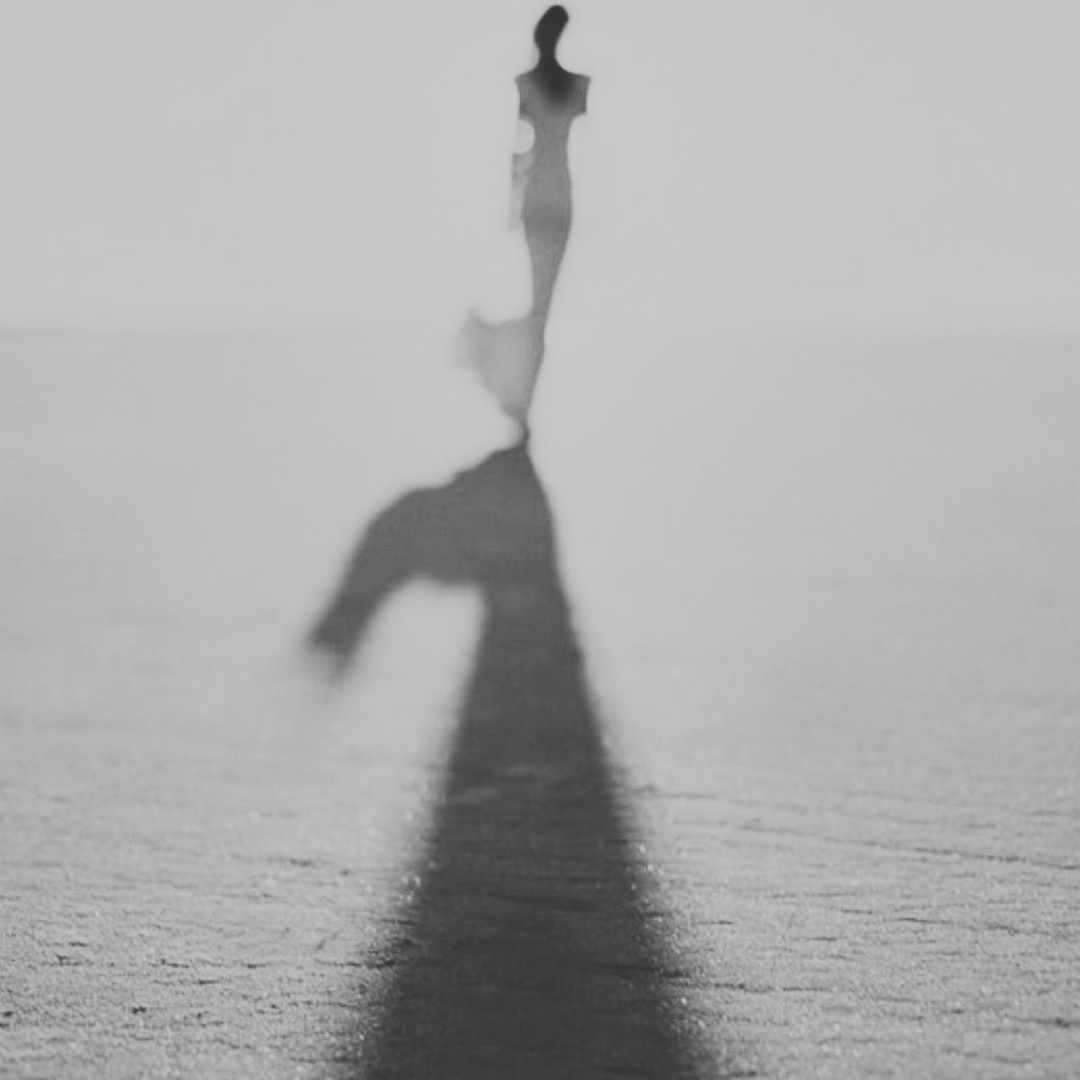 donna di spalle che cammina verso la luce - immagine simbolica che rappresenta la fase alchemica albedo