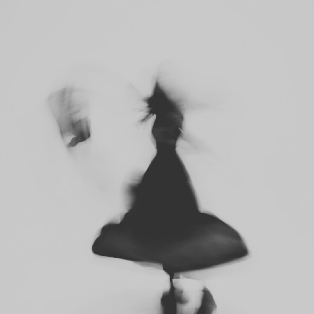 Figura di una donna con un ombrello, vista dal basso, in bianco e nero con effetto sfocato.