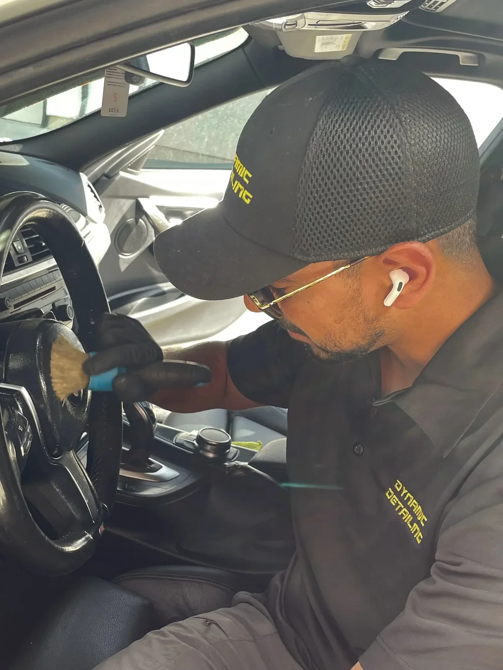 Detailing technician cleaning a vehicle interior