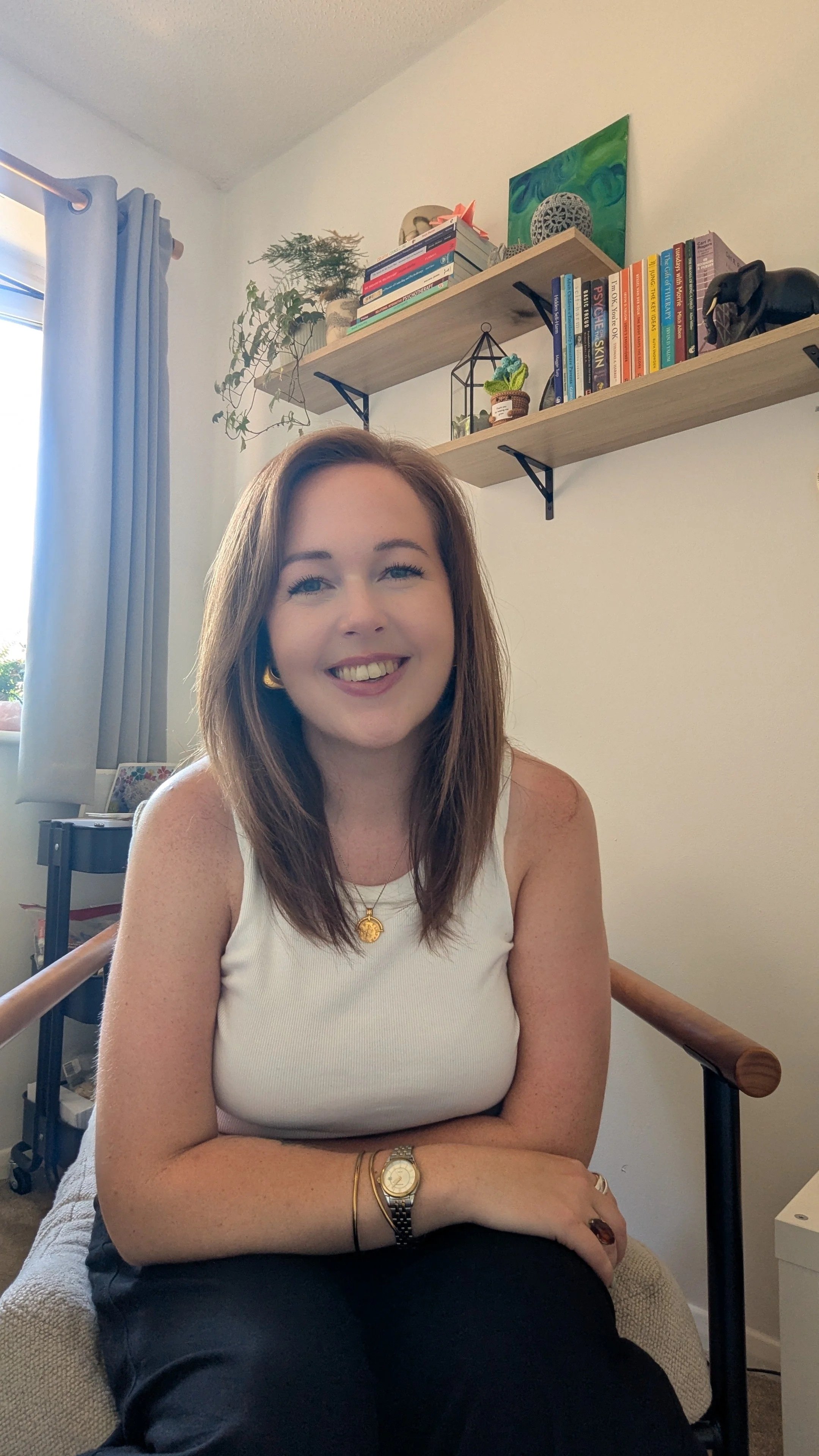 woman with brown hair in white tank top. therapist