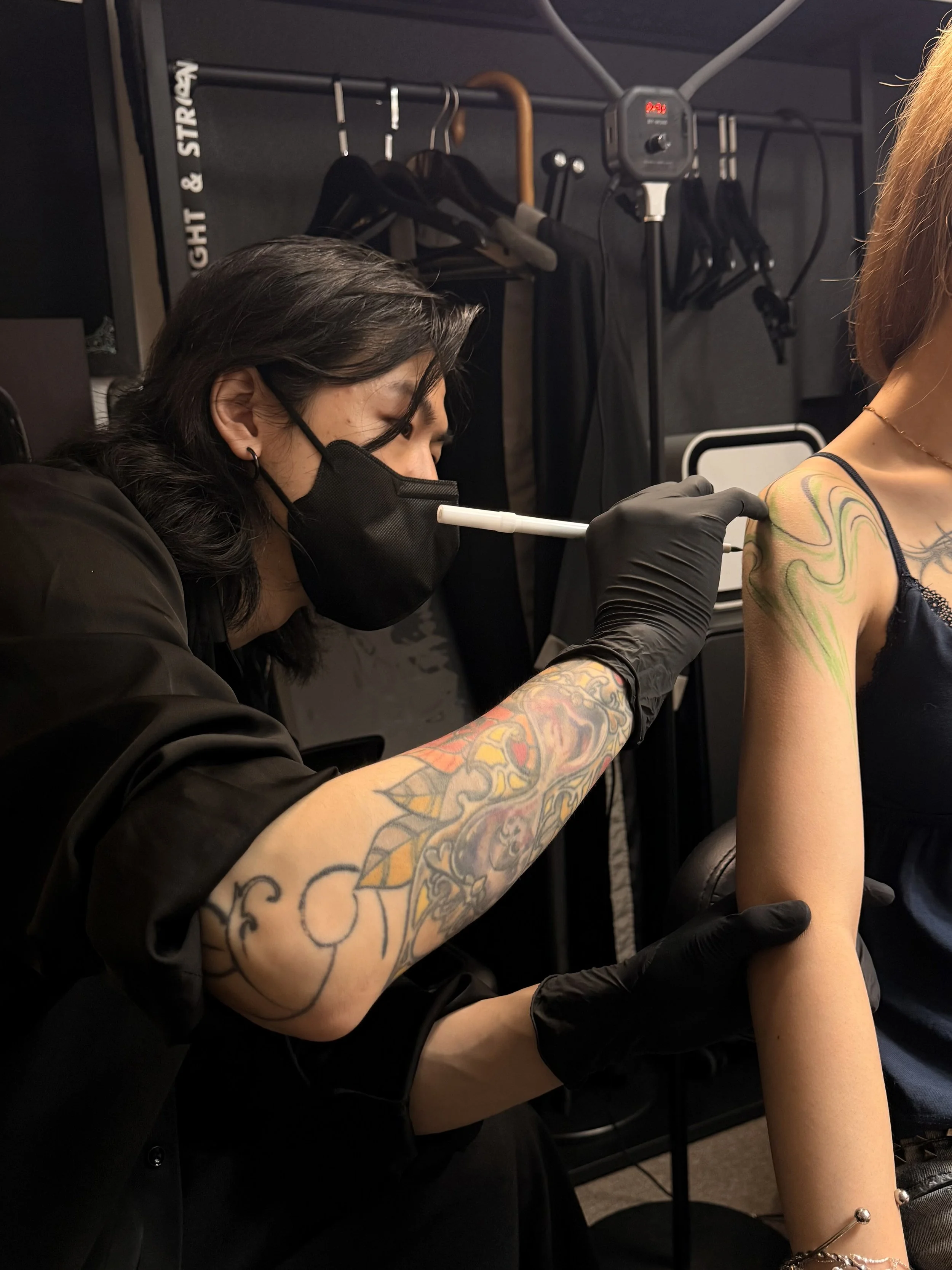 Professional tattoo artist crafting custom arm tattoo at POETAILOR Studio Hong Kong