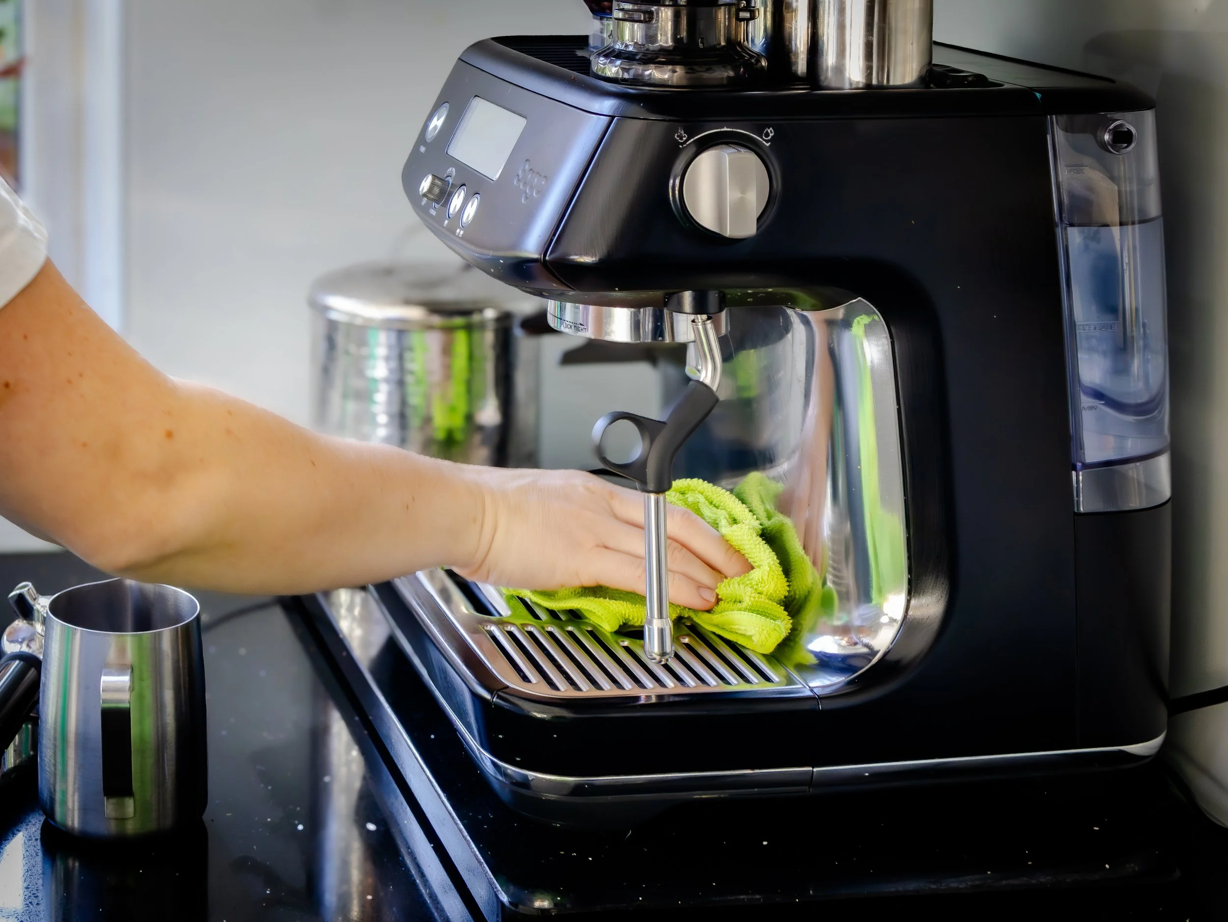 A cleaner, polishing a coffee machine