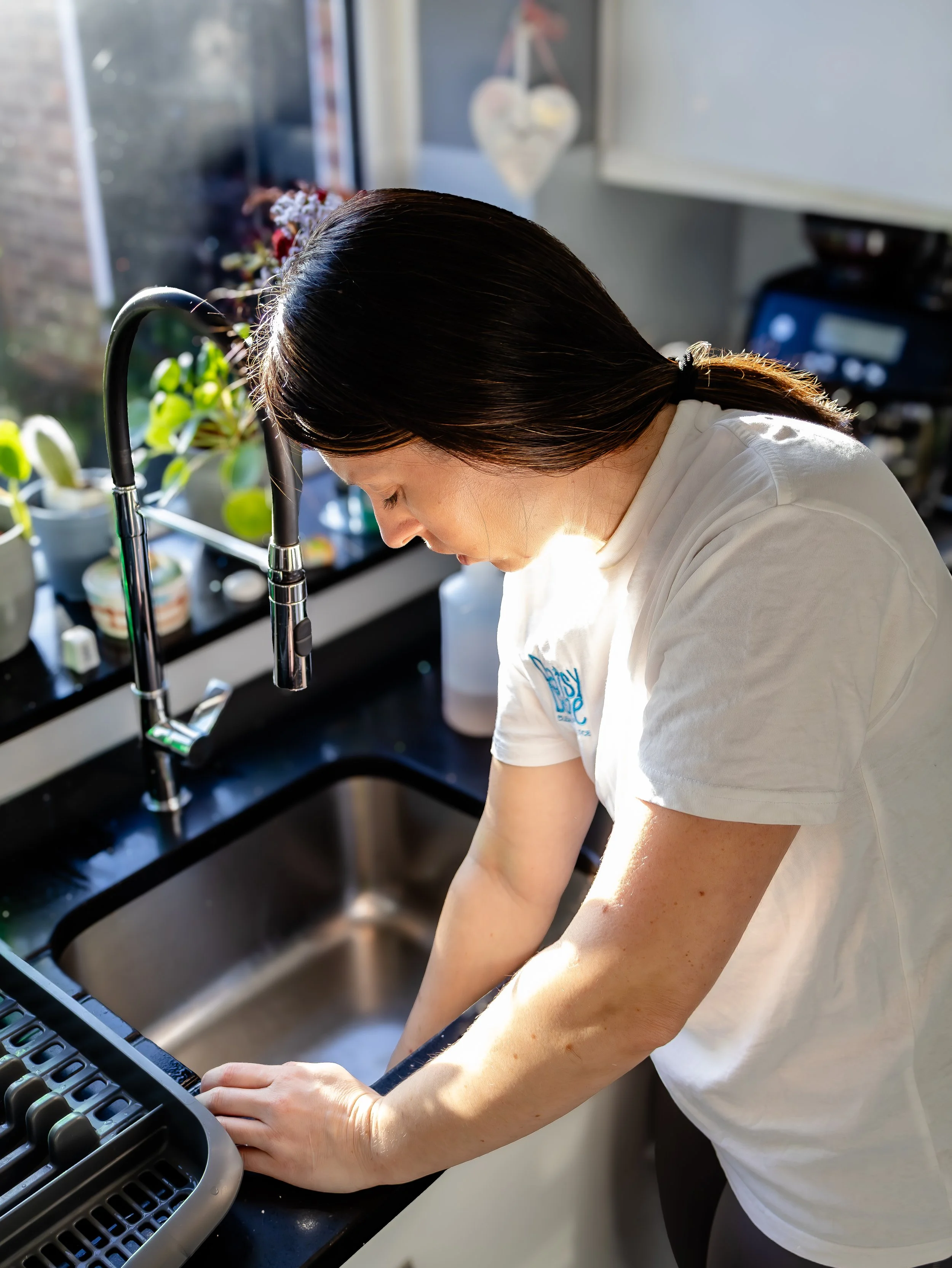 A female cleaner cleaning the sink