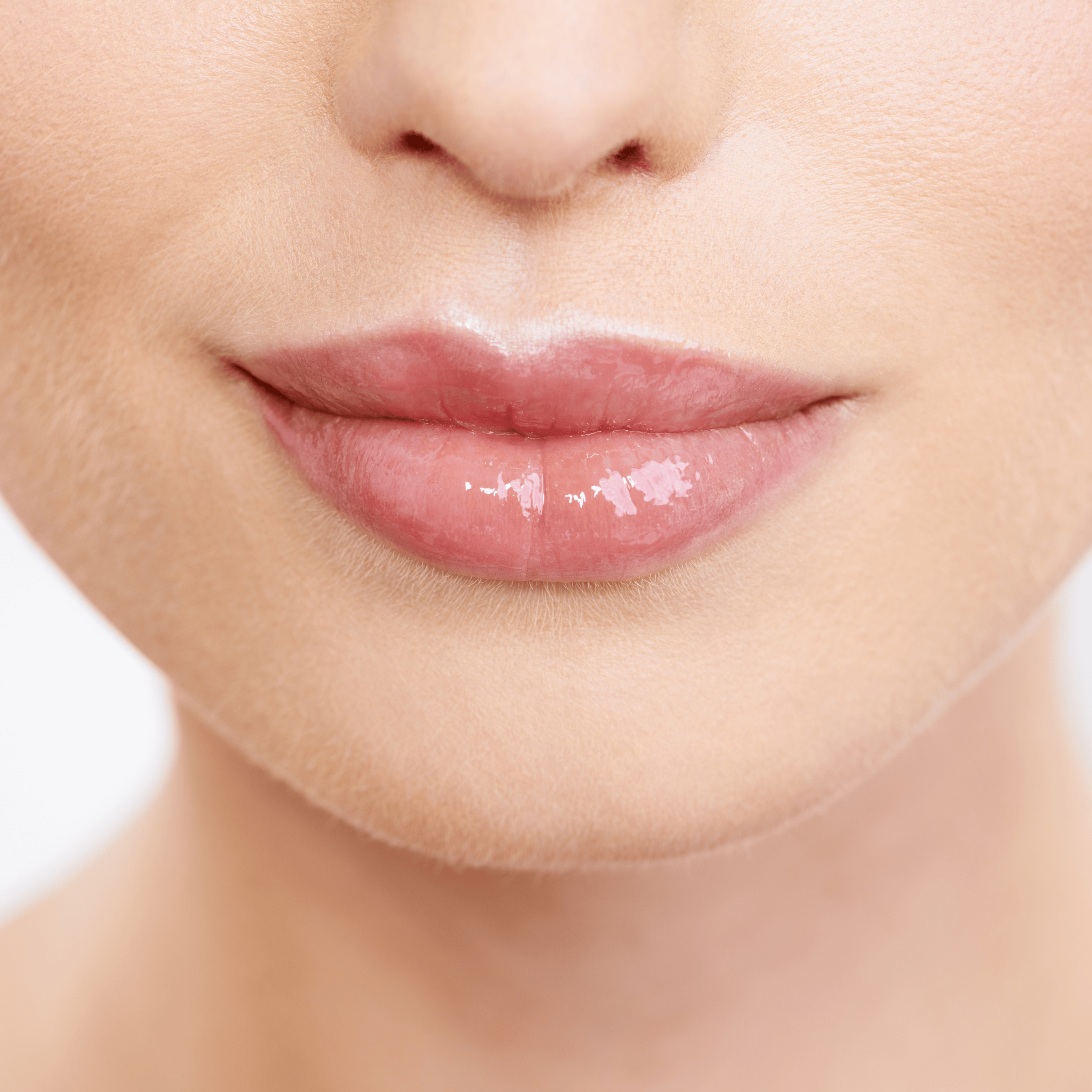 Close-up of a woman's lips with glossy pink lipstick.