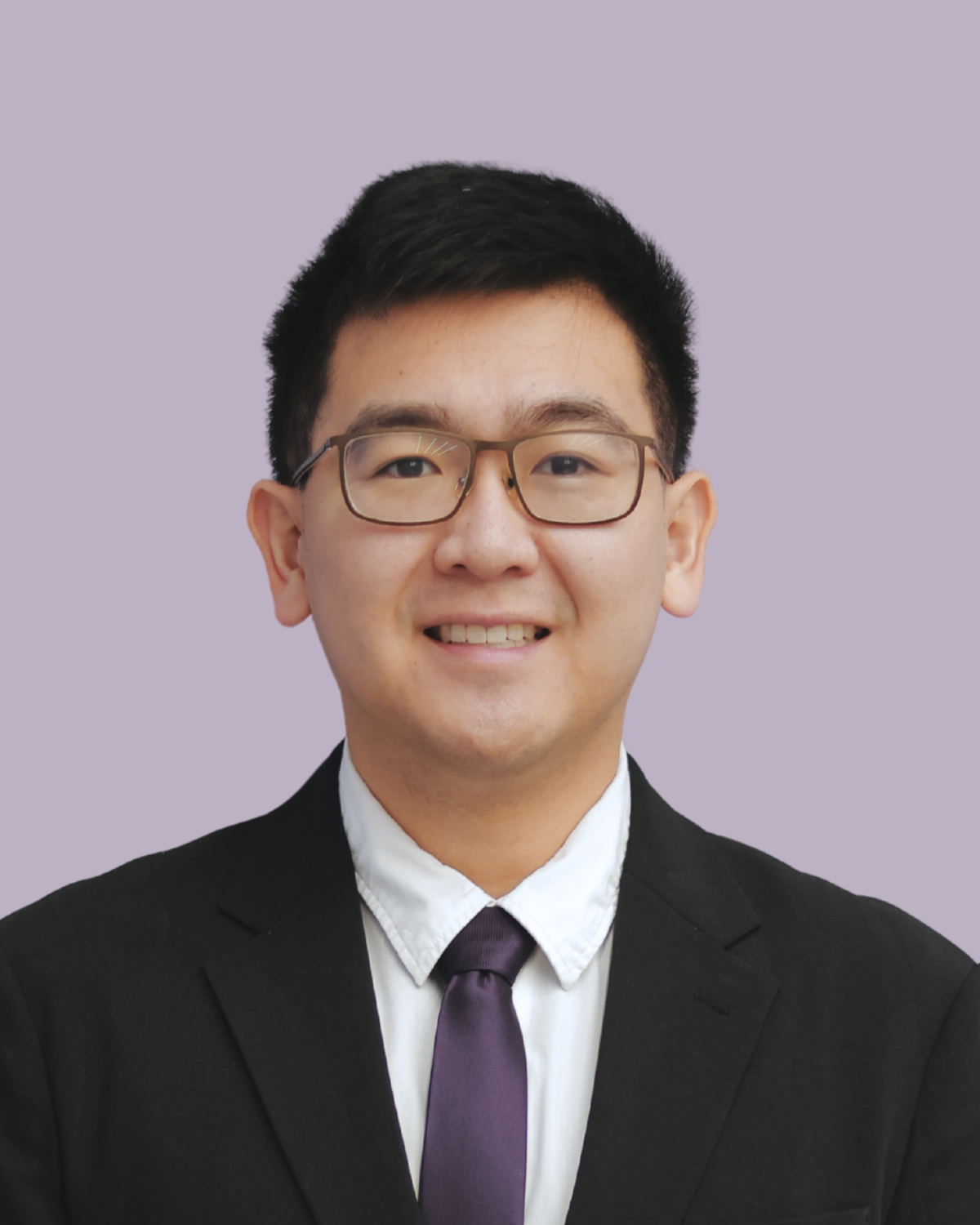 Headshot of a young man wearing glasses, a black suit, a white shirt, and a purple tie, smiling against a light purple background.