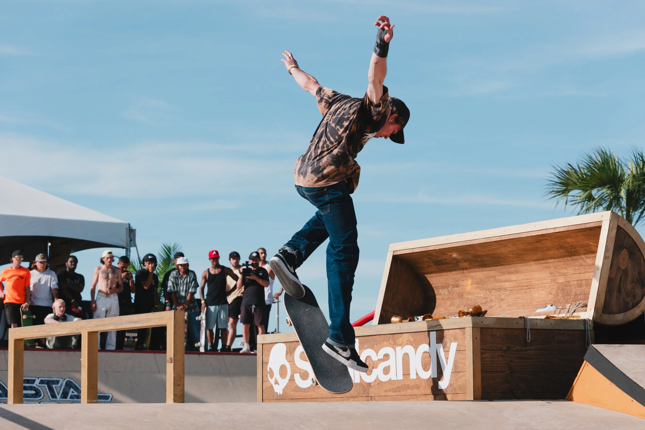 Skateboarder performing trick on ramp with spectators and treasure chest