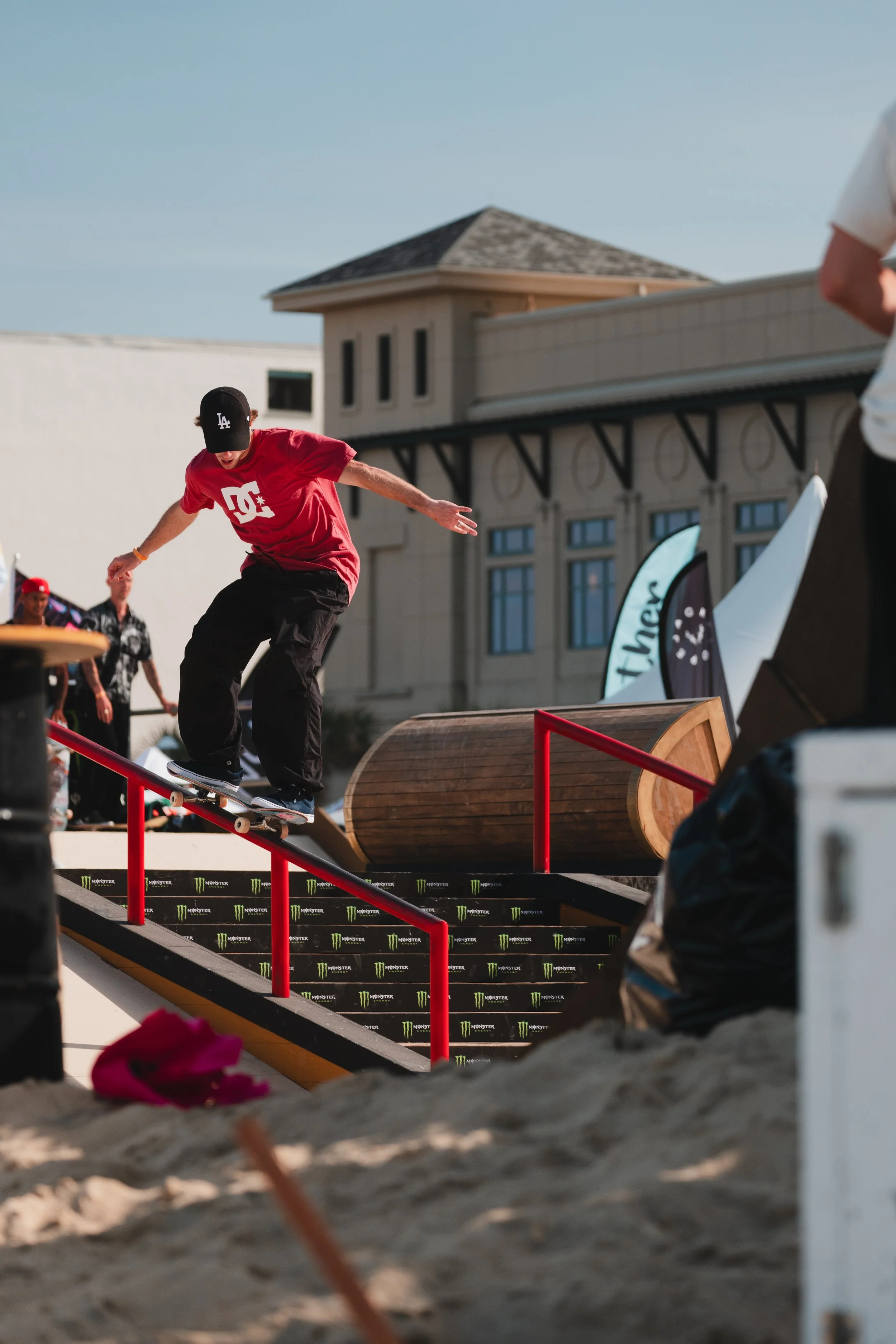 Skateboarder performing a trick on a rail at an outdoor skate park.