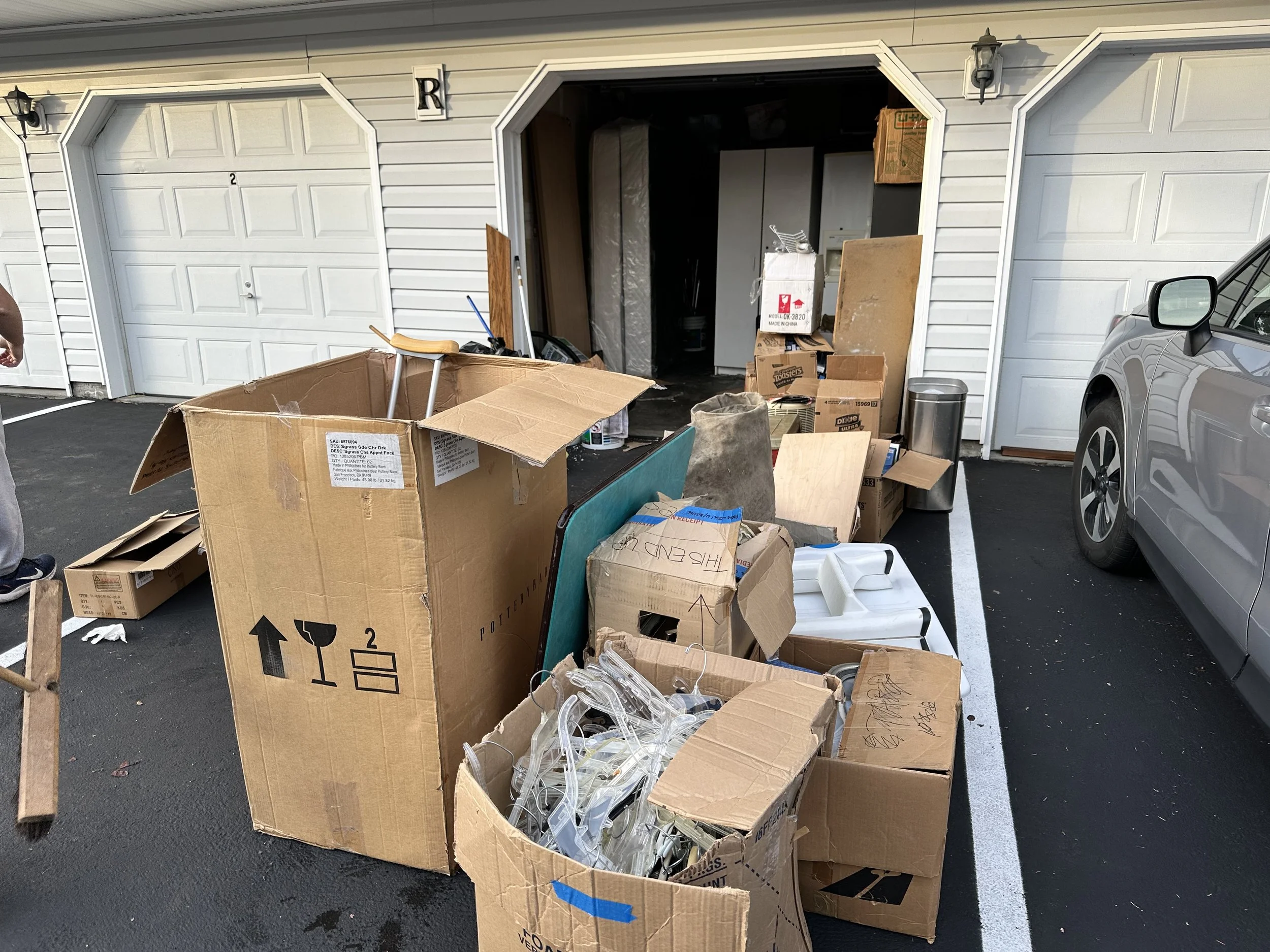 Items from garage sitting in driveway in front of garage being sorted.