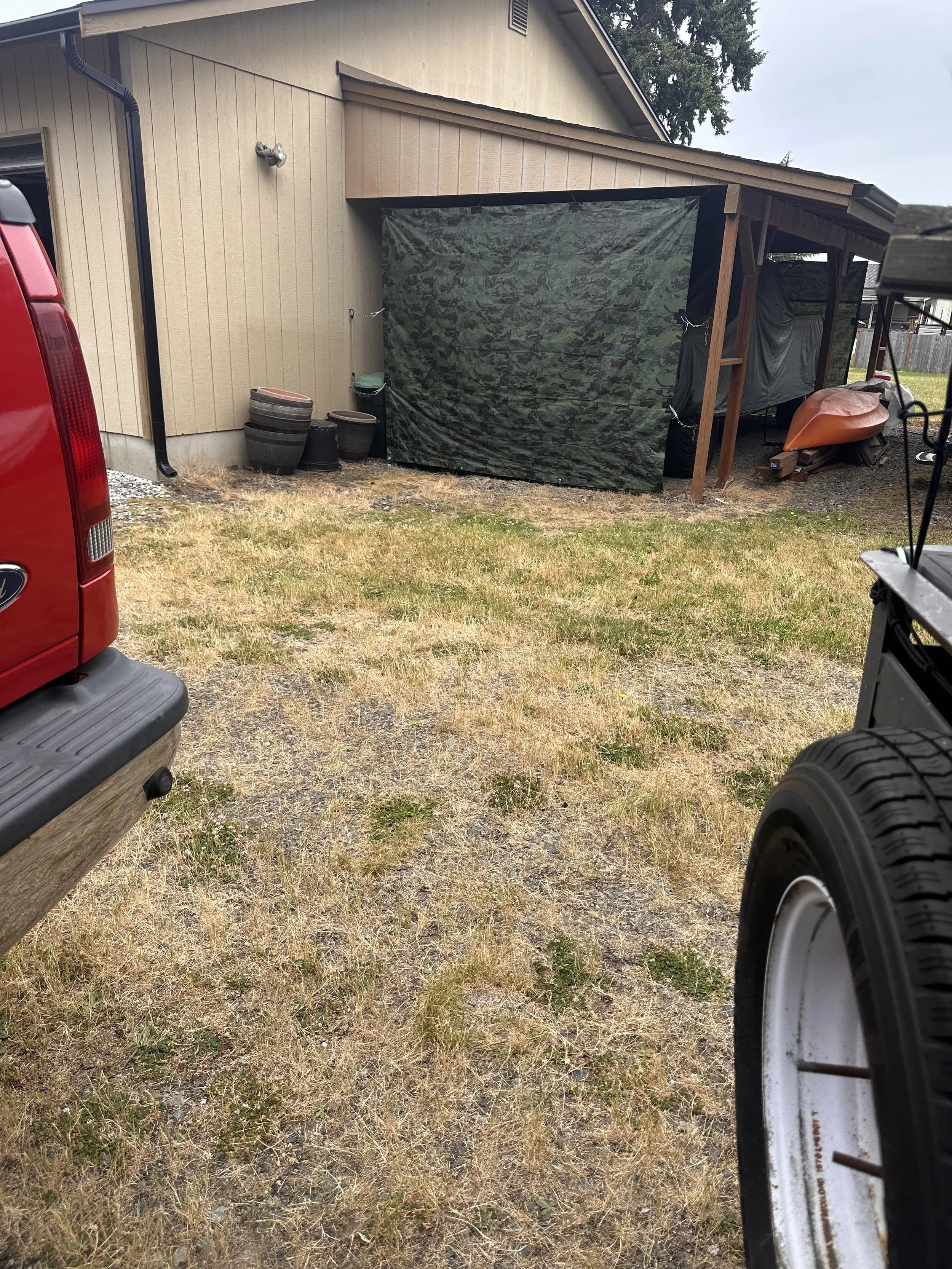 Cleared outdoor area beside a Puyallup home after removing an old lawn mower, fire pit, and unwanted yard equipment.