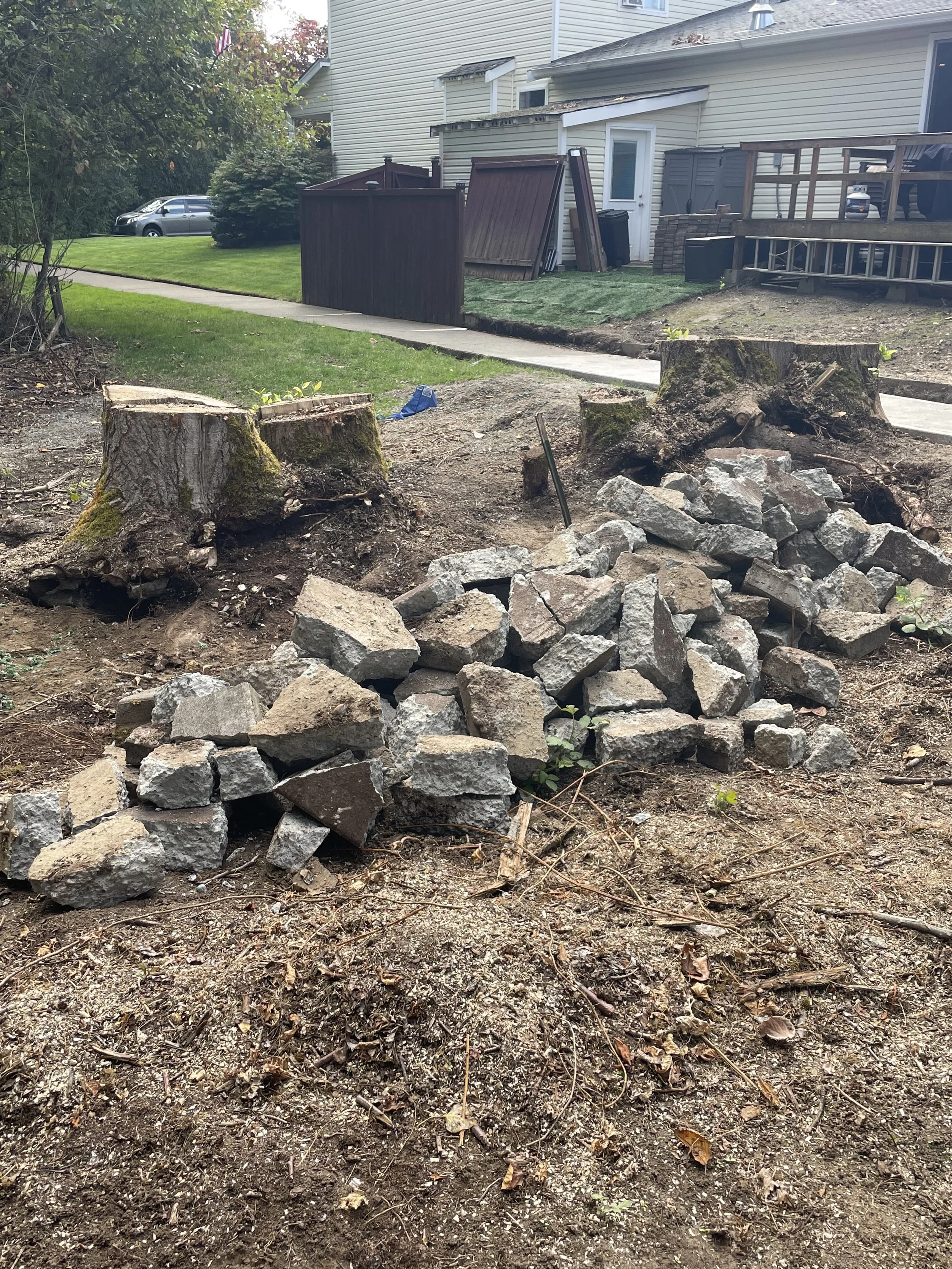 Pile of broken concrete sidewalk debris awaiting removal at Sweetbriar HOA in Pierce County, Washington.