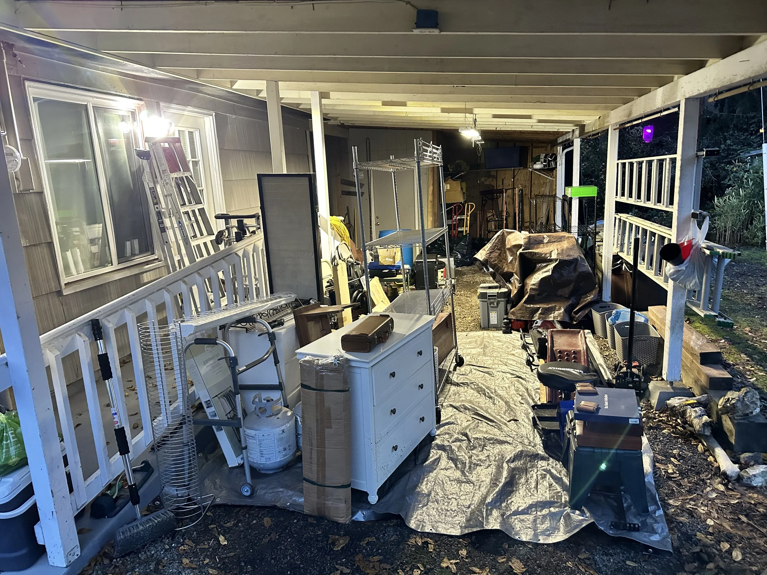 Items laid out on tarps in a carport during the sorting stage of a garage cleanout in Puyallup.