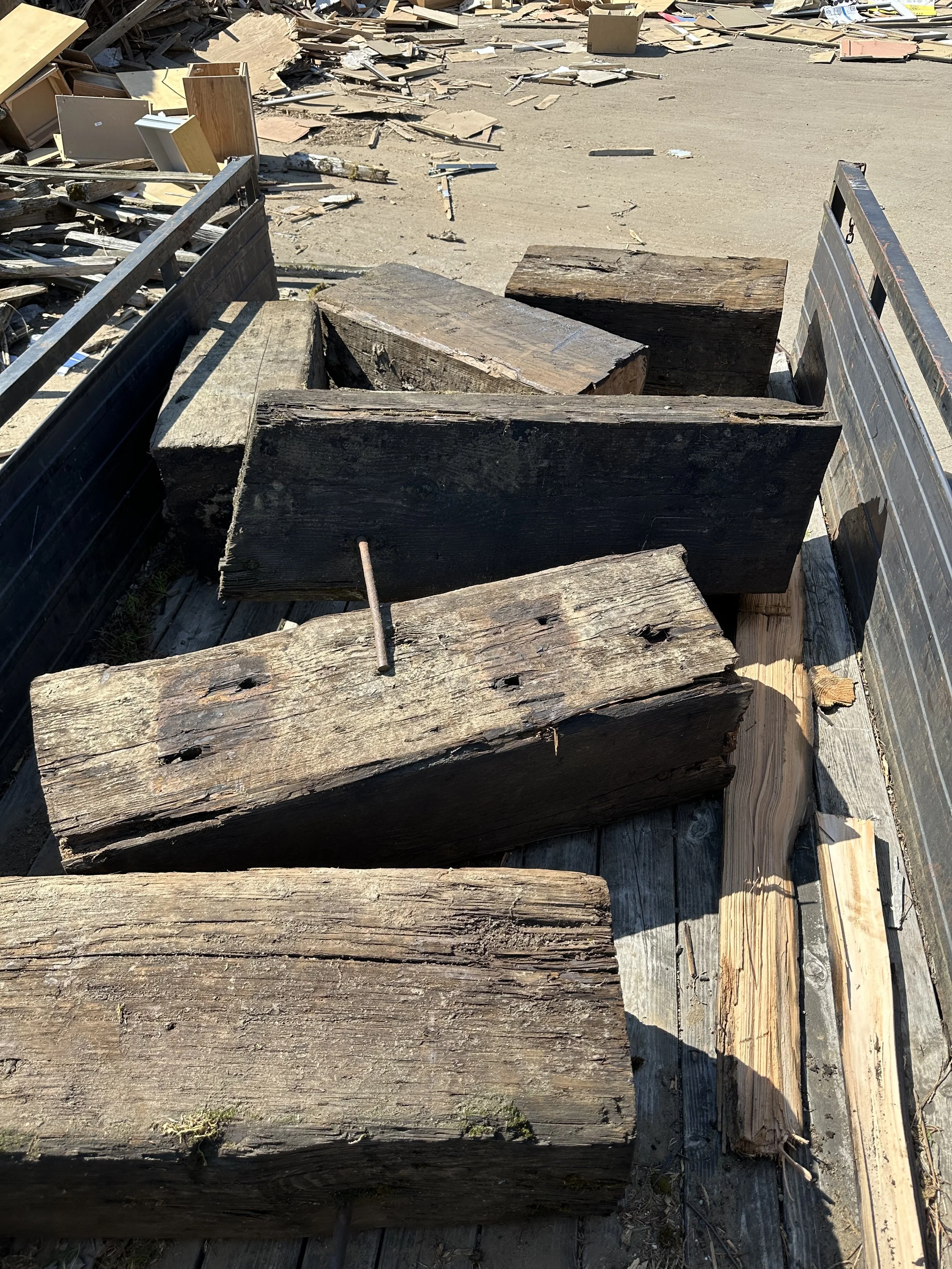 Disposal — at the junkyard, getting ready to roll the beam chunks off the trailer.