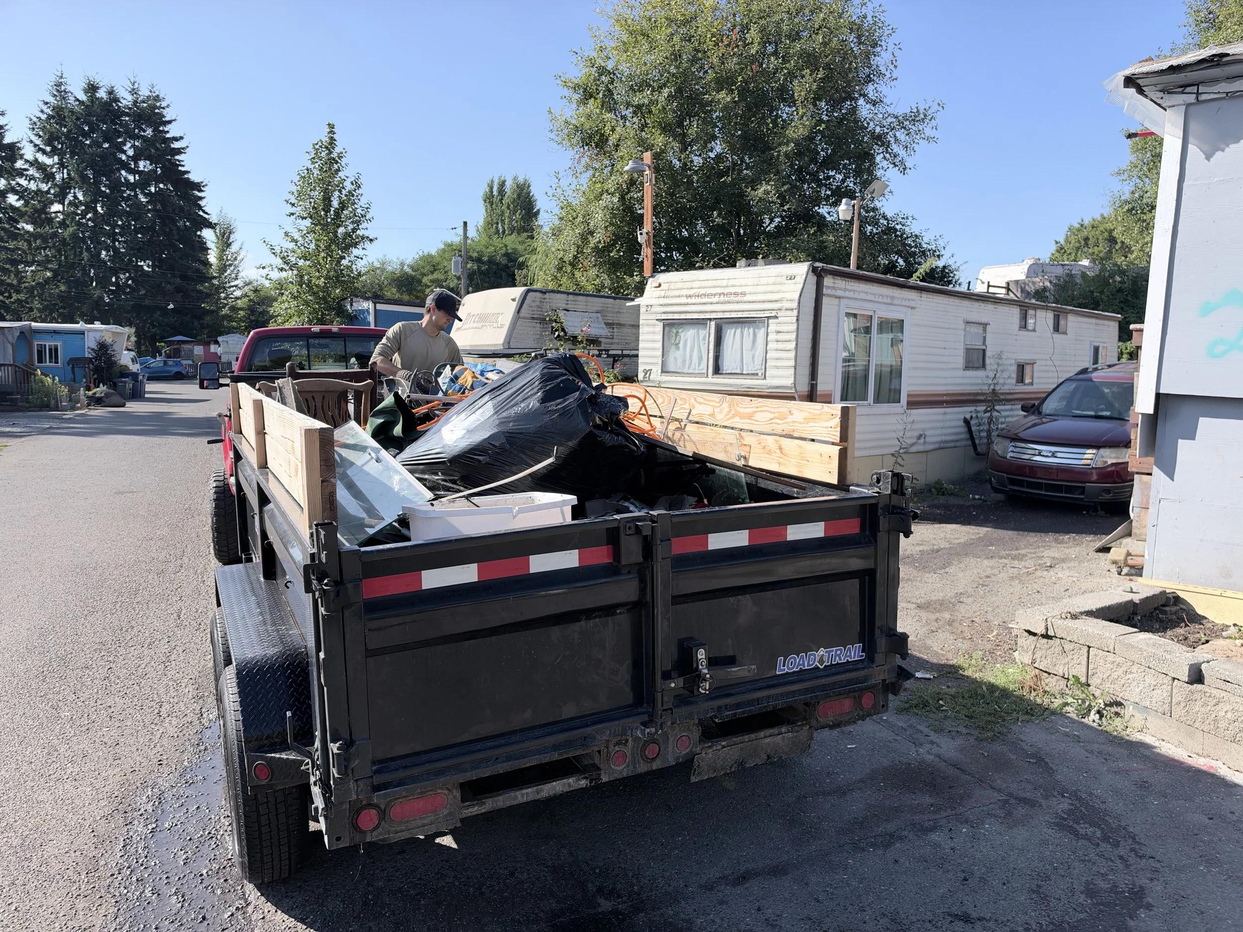 Just Ask Alex dump trailer loaded with furniture and debris during a residential eviction property clean-out in Tukwila, Washington.