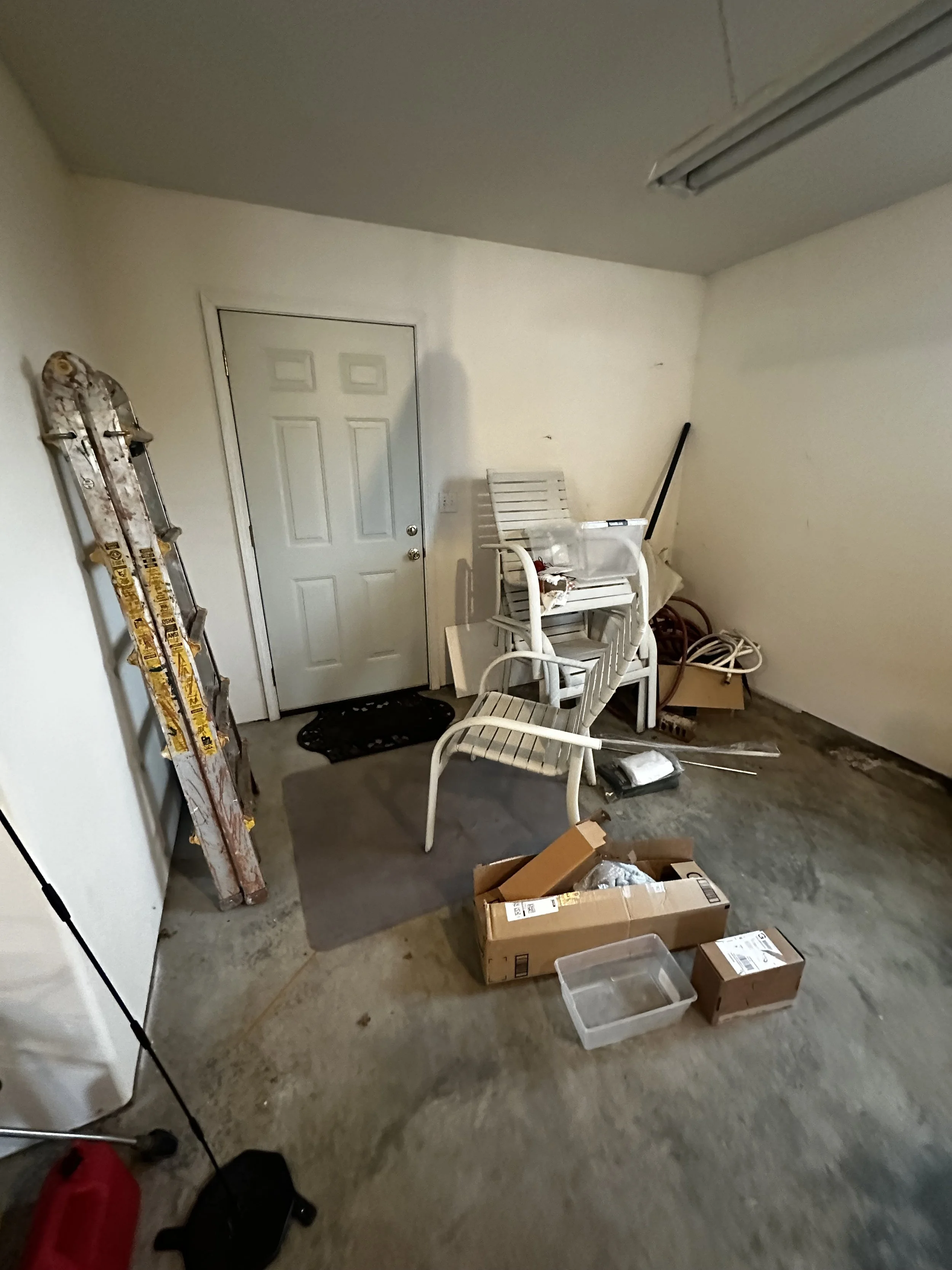Before — Garage clutter pile with chairs and boxes.