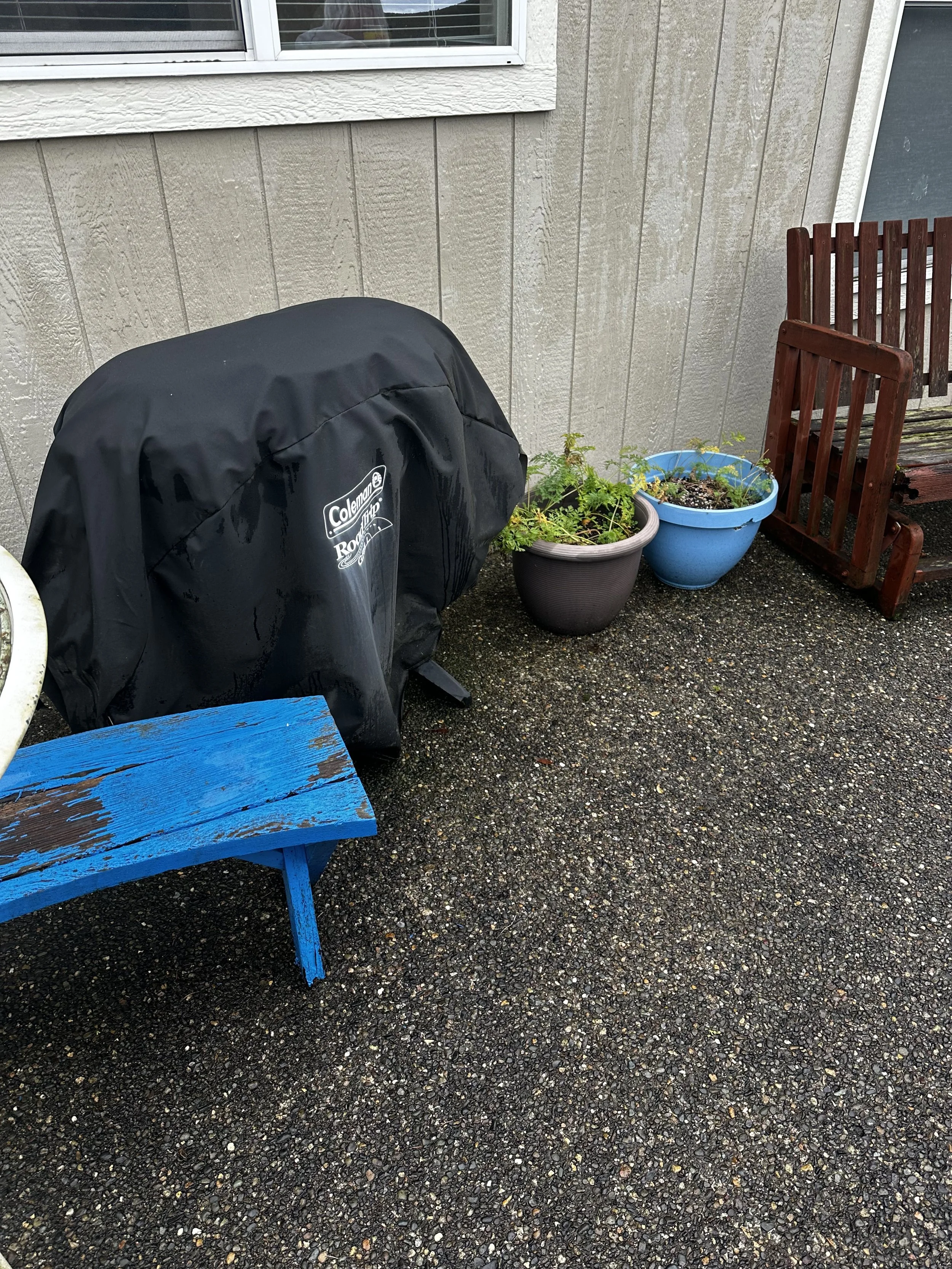 Before — Grill, planters, and bench pieces on the patio.