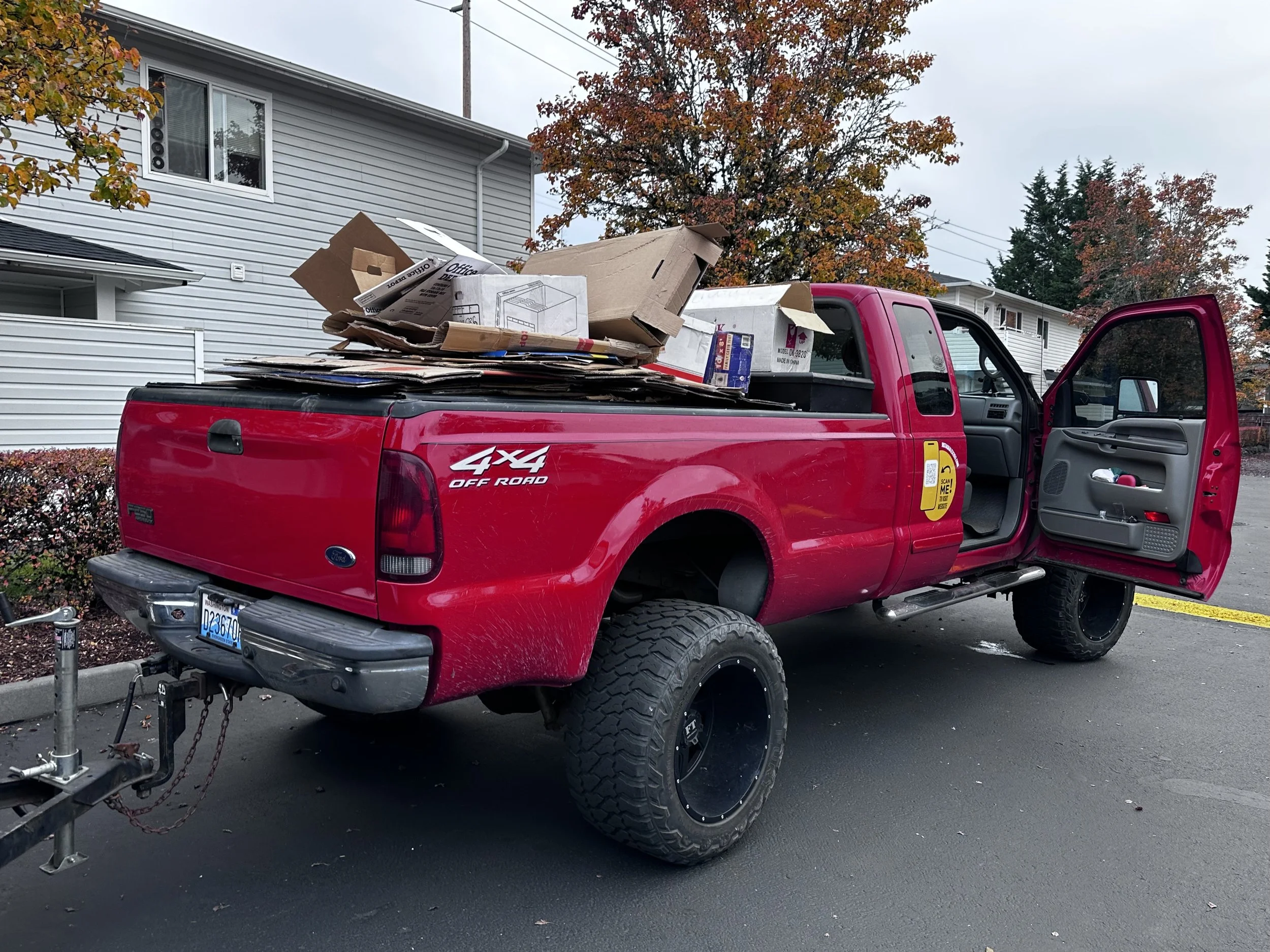 Pickup truck and trailer fully loaded with debris during final stages of a large garage cleanout in Pierce County.