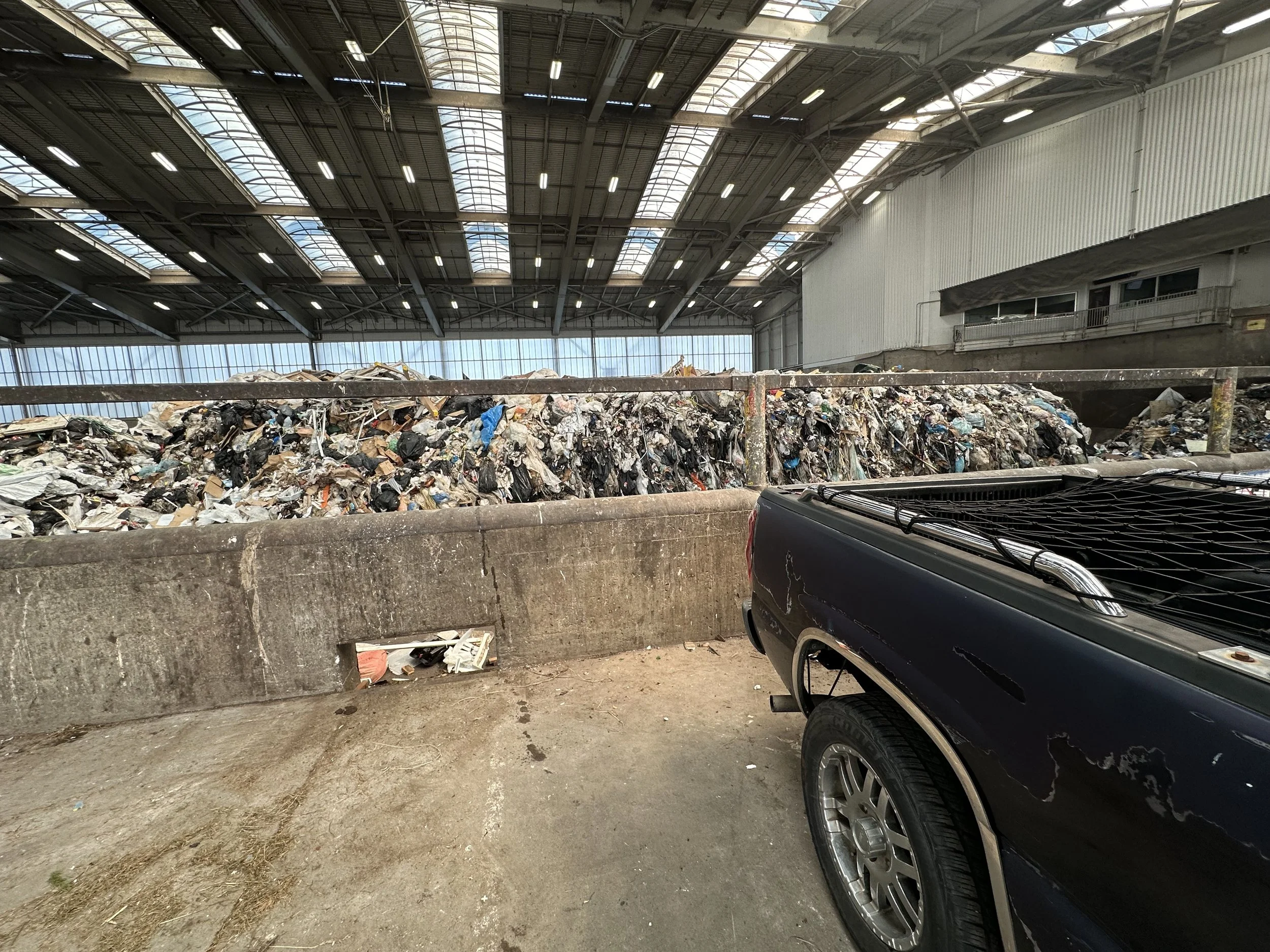 Truck unloading household junk at Bow Lake Transfer Station in King County, Washington, showing where residential waste is disposed and sorted for recycling.