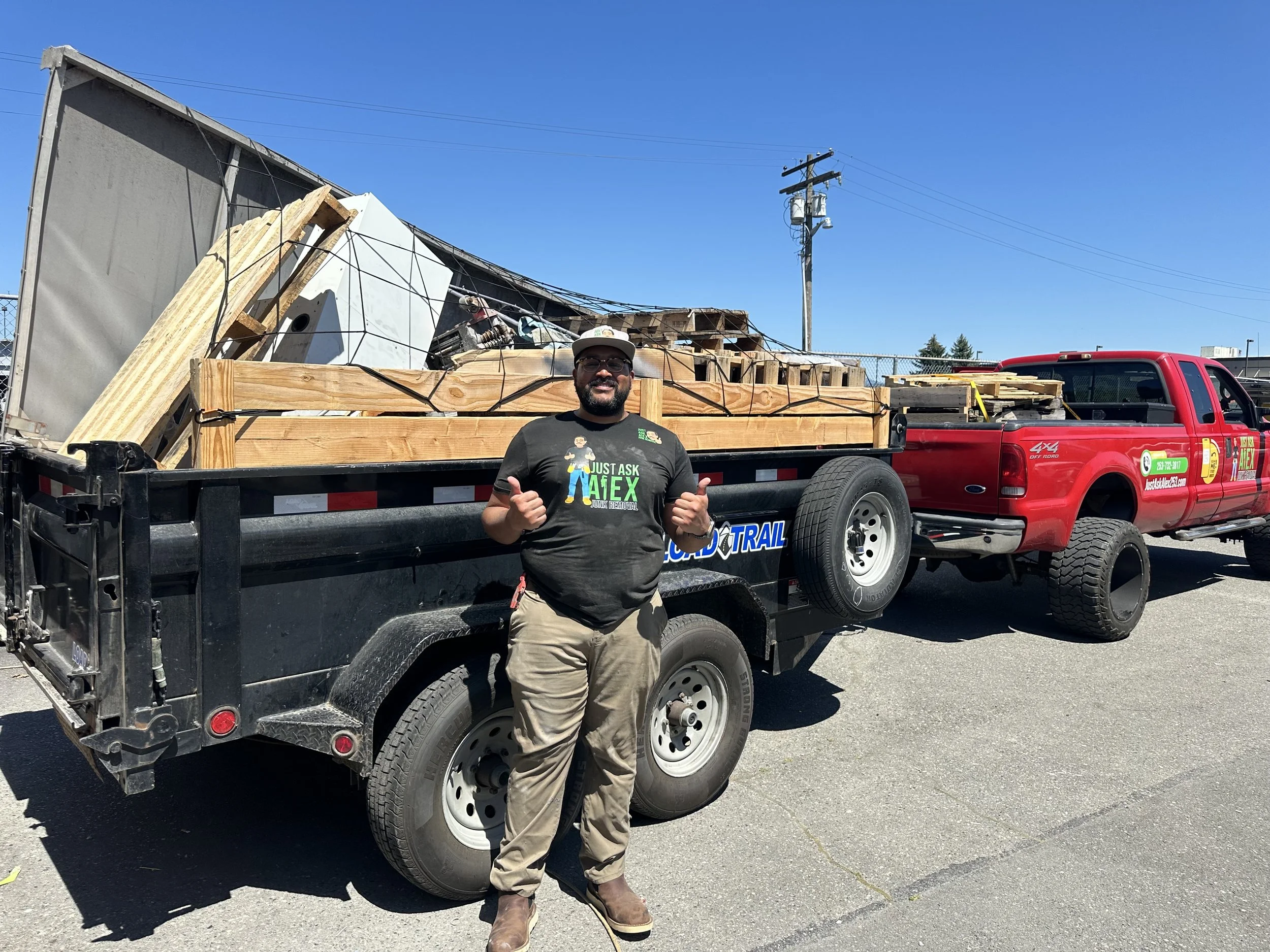 Just Ask Alex with a loaded dump trailer and red work truck following an automotive shop junk removal project for Dent Wizard.